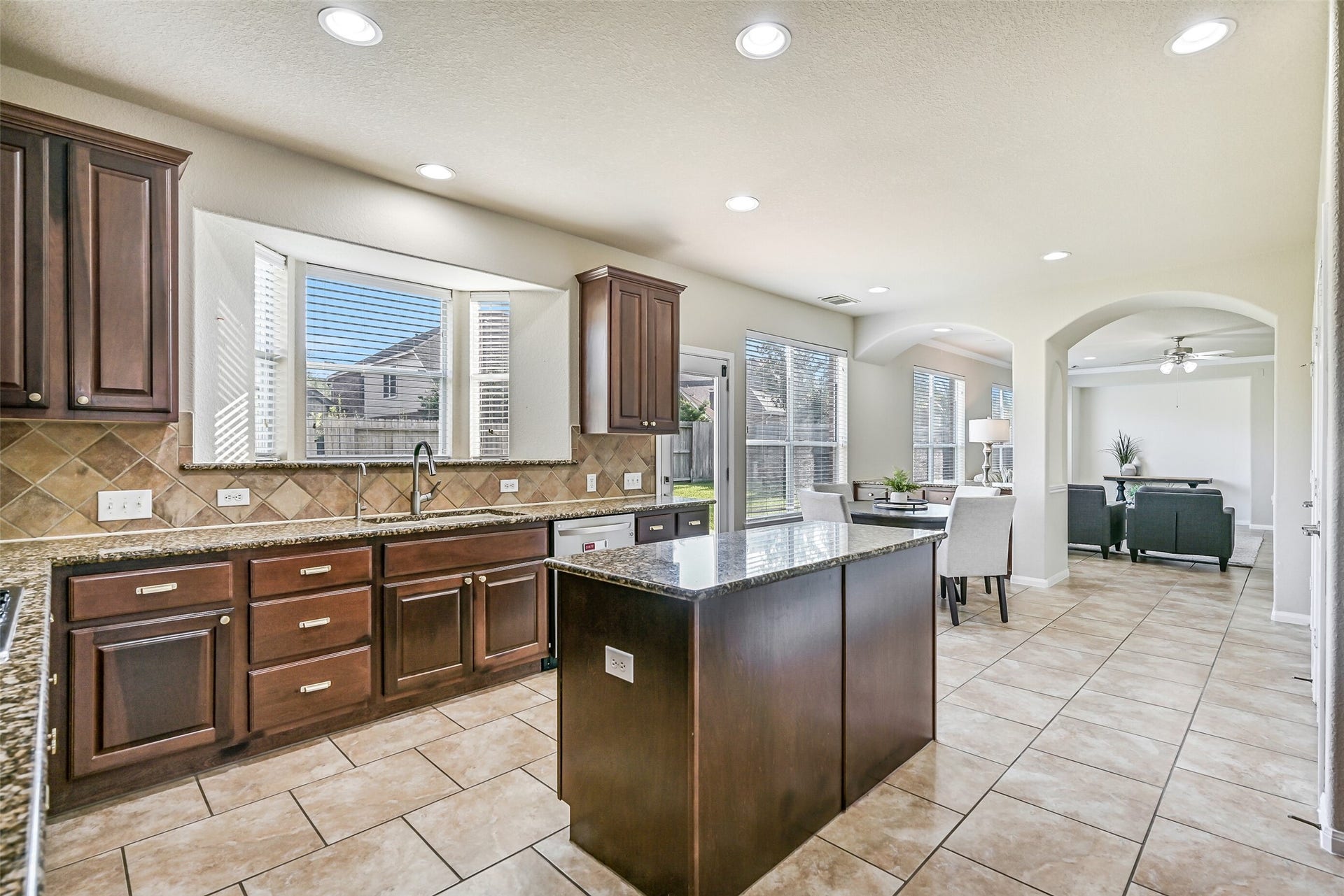 2508 Rockygate Lane, Friendswood, TX 77546 The large center island anchors the space and is complemented by a gas cooktop, built-in microwave, wall oven, and expansive granite surfaces. Recessed lighting and neutral finishes create a bright, welcoming environment that will easily become the hub of daily life.