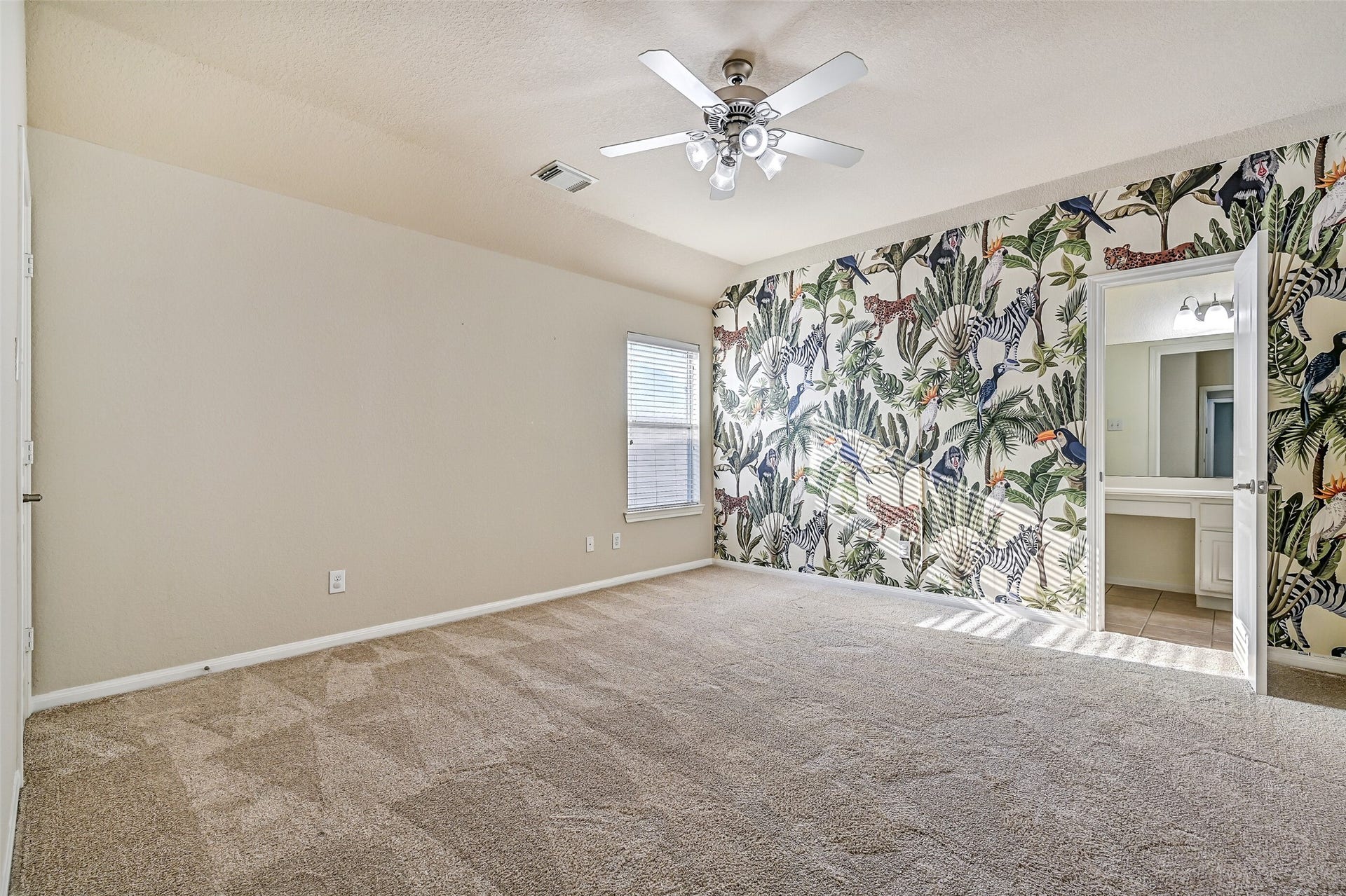 2508 Rockygate Lane, Friendswood, TX 77546 The fourth and final bedroom in the home is generously sized and features fresh neutral paint, plush new carpet, an elevated gambrel ceiling with a lighted ceiling fan, a side-facing window with 2-inch blinds, and a step-in closet. A fun designer accent wall adds character and personality to the space, while direct access to the shared Jack & Jill style bathroom provides added convenience.