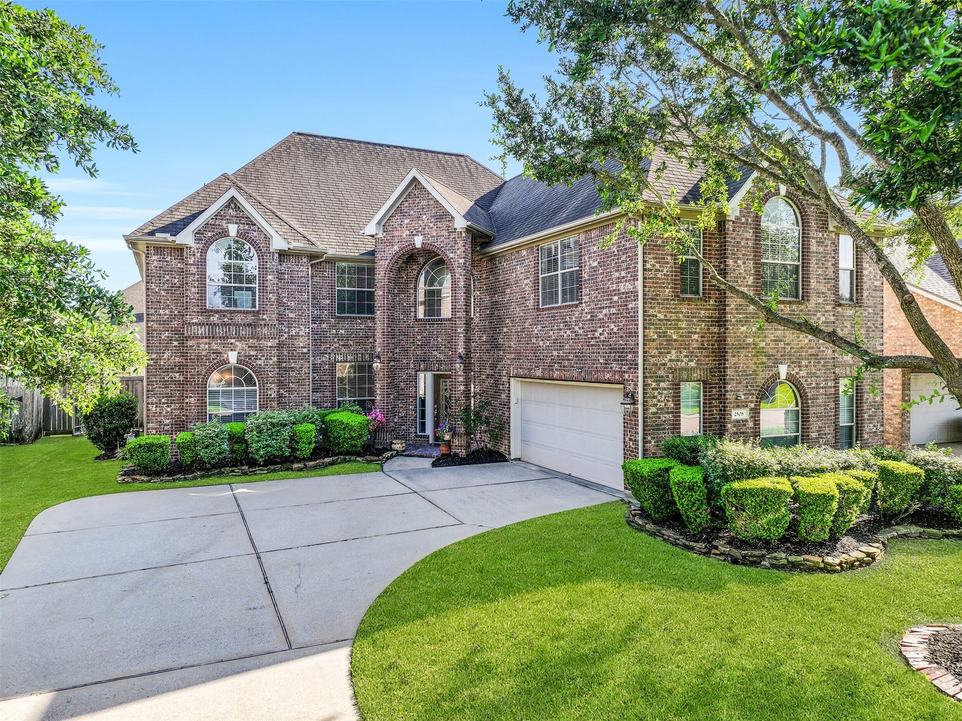 2508 Rockygate Lane, Friendswood, TX 77546 A sweeping driveway leads to the two-car garage and covered entry of this spacious family home. Graceful architectural details, soaring arched windows, and well-maintained landscaping create a warm first impression, while the freshly painted exterior adds a crisp, move-in-ready feel.