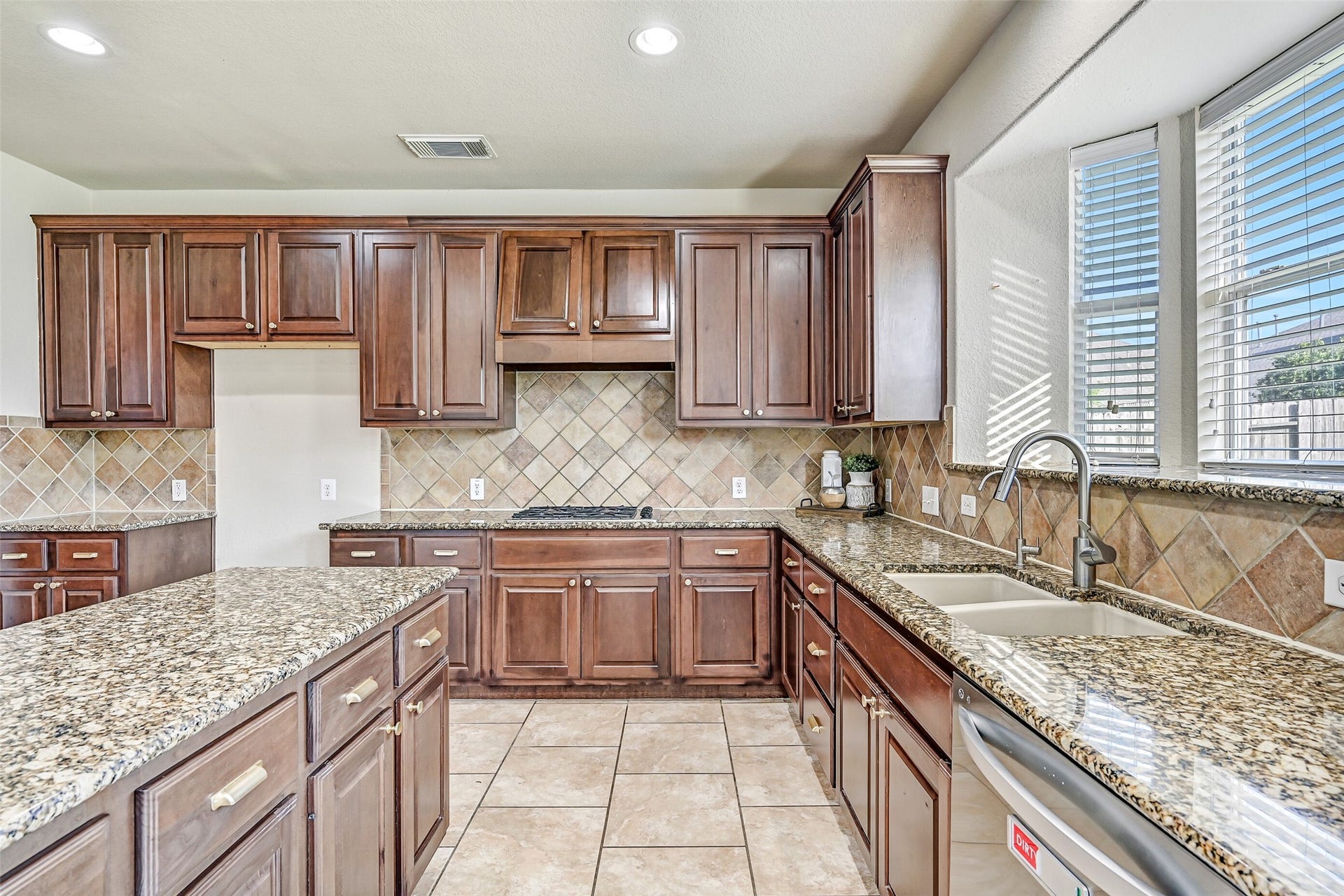 2508 Rockygate Lane, Friendswood, TX 77546 Designed with both functionality and style in mind, the kitchen features granite counters that stretch for days, a dual-basin undermount sink beneath sunny backyard-facing windows, stainless dishwasher, and ample workspace for preparing everything from weeknight dinners to holiday feasts.