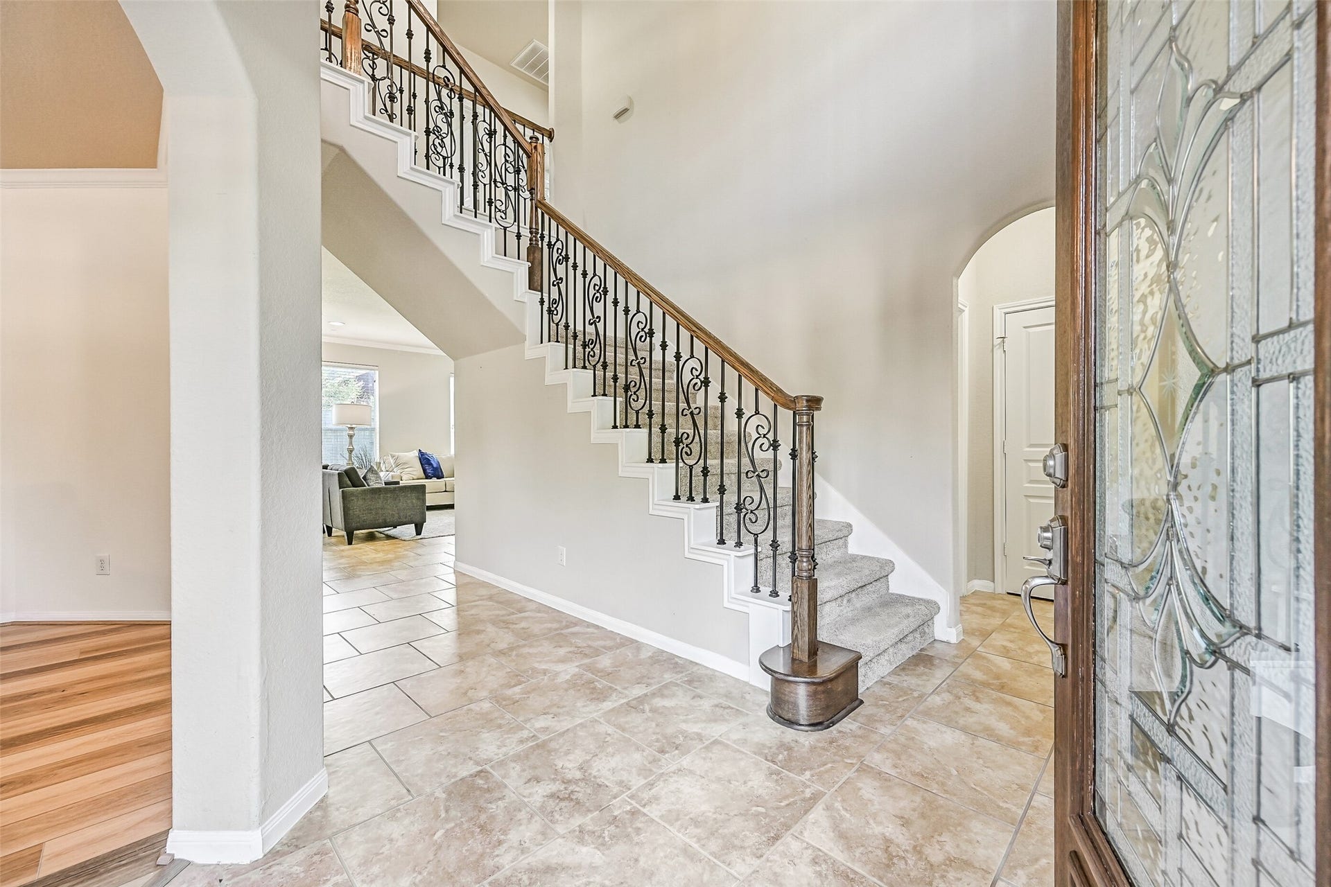 2508 Rockygate Lane, Friendswood, TX 77546 Step inside to a dramatic two-story foyer highlighted by fresh neutral paint, brick-laid ceramic tile flooring, and an elegant split staircase with decorative wrought iron balusters and plush new carpet. Natural light pours through the leaded glass front door, creating a bright and welcoming first impression.