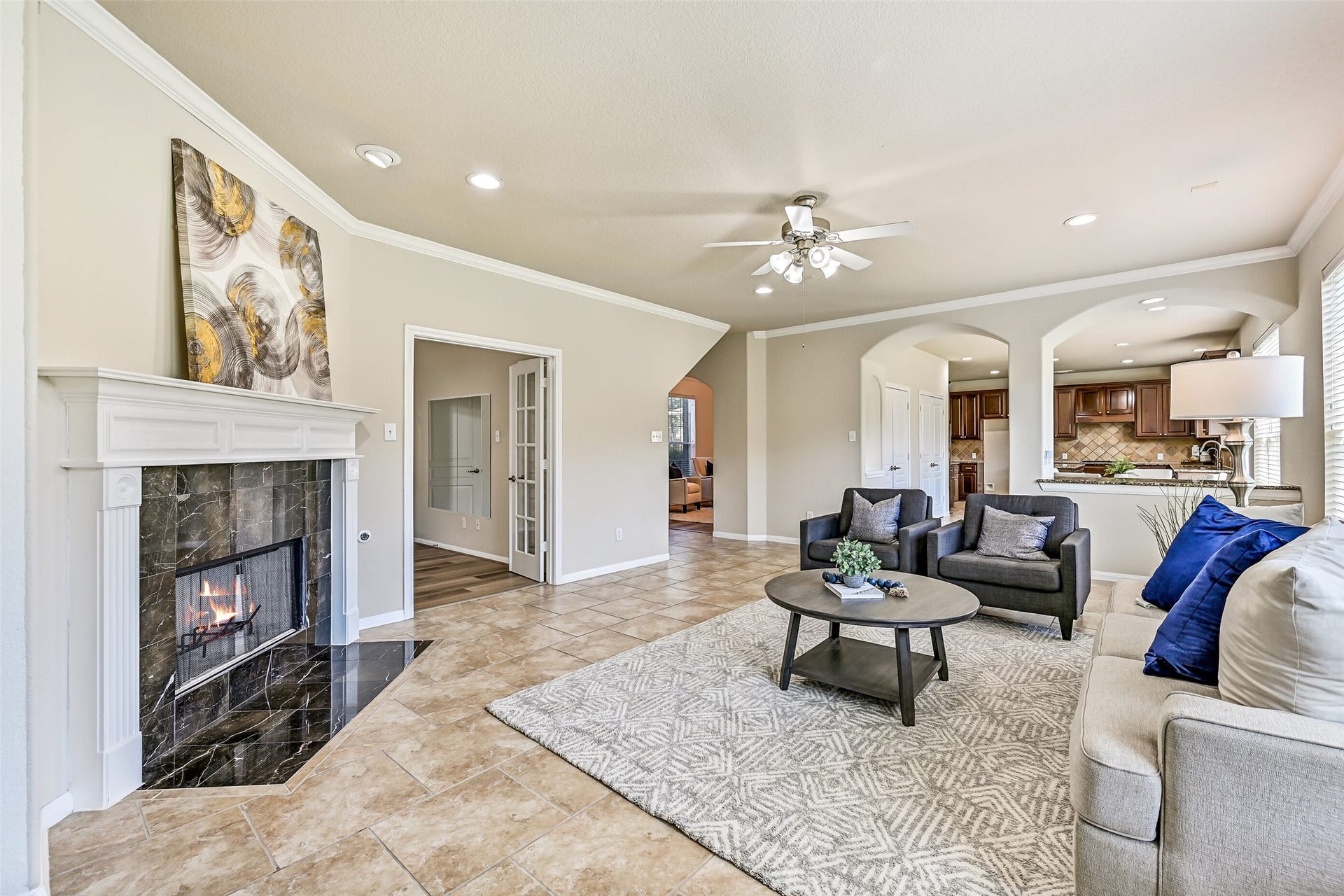 2508 Rockygate Lane, Friendswood, TX 77546 A corner-set gas log fireplace with a striking granite tile surround and classic white mantle anchors the family room and creates a natural focal point for gatherings. From this vantage point, notice the open connection to the kitchen, breakfast room, and adjacent study, enhancing the home's functional flow.