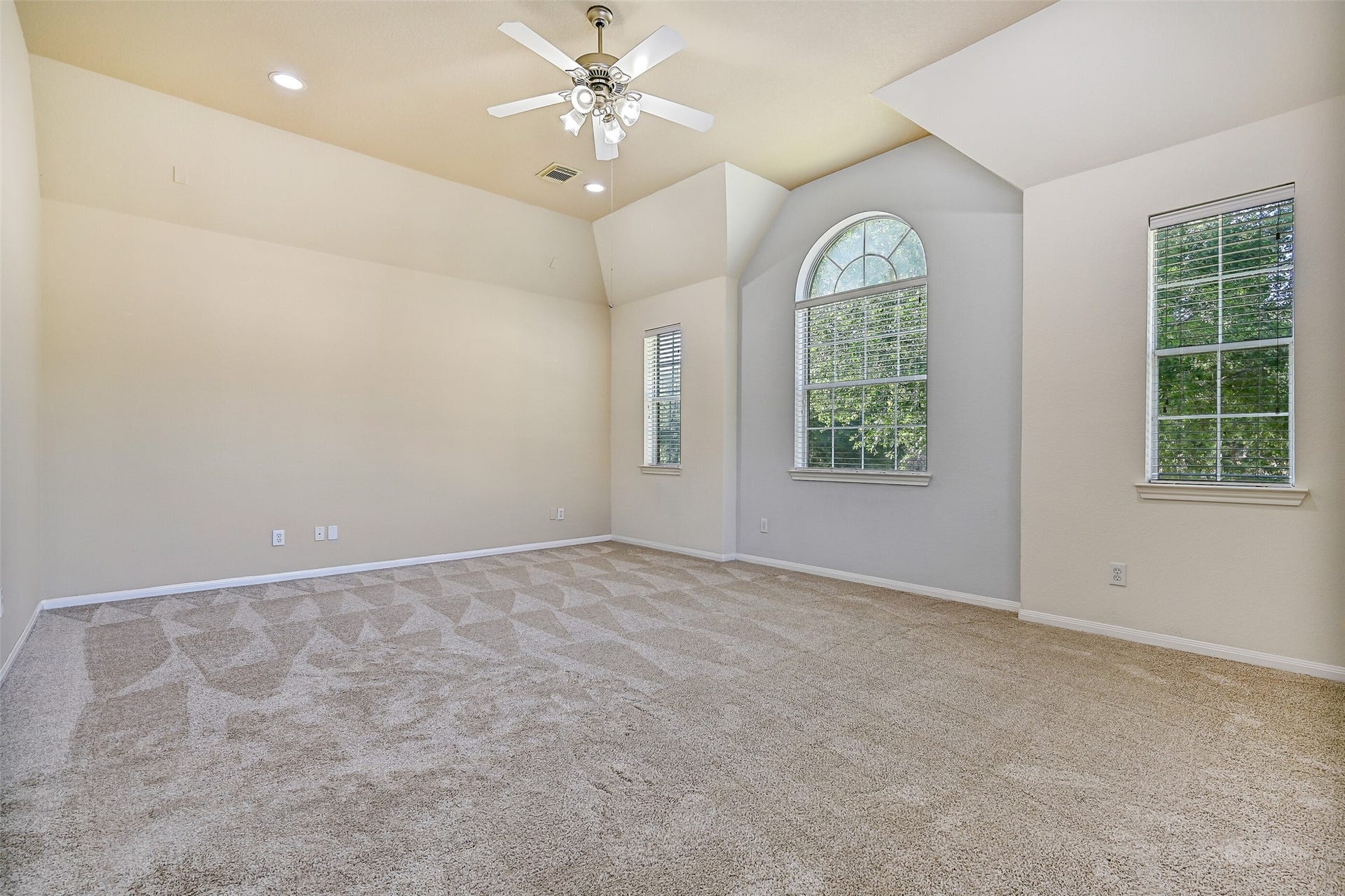 2508 Rockygate Lane, Friendswood, TX 77546 From this angle, the impressive scale of the game room is on full display. Multiple windows, including a striking arched window, fill the space with natural light, while the vaulted ceiling enhances the open feel. Whether you envision a pool table, home theater, fitness area, or playroom, there's room here for it all.