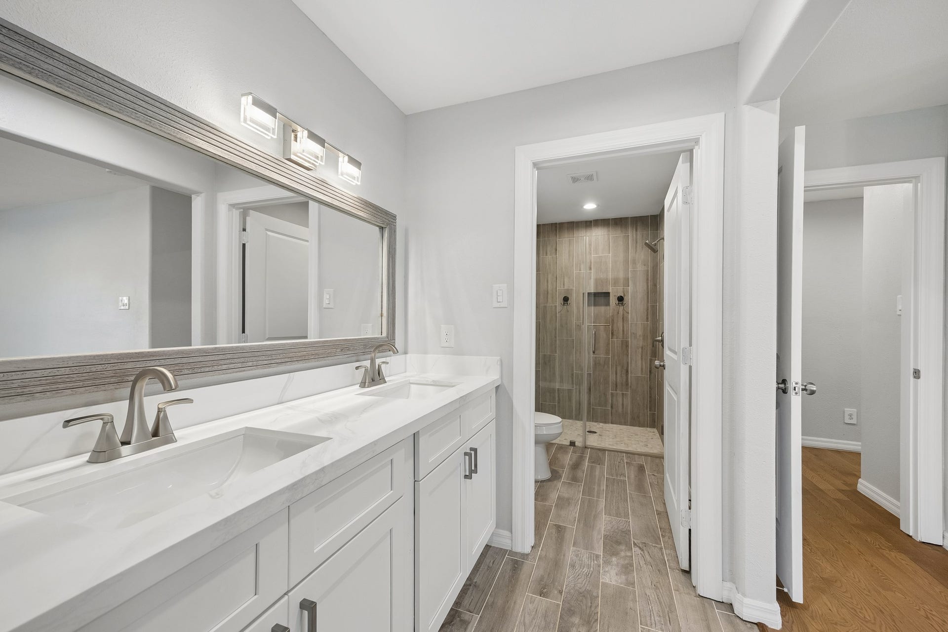 An unfurnished view of the primary suite from the entry, highlighting the spacious layout and French doors leading directly to the backyard.