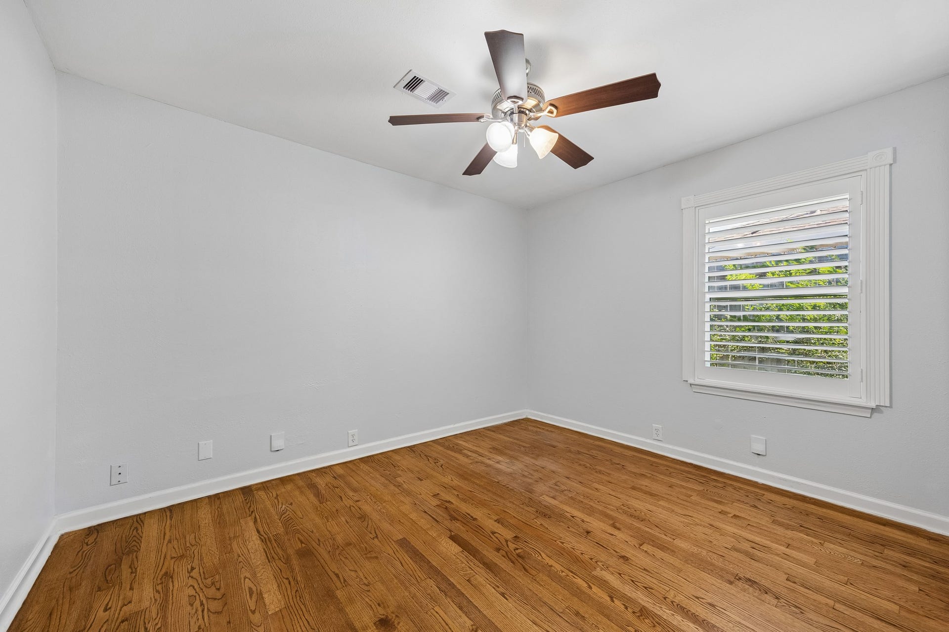 One of two secondary bedrooms positioned near the front entry, offering a bright, flexible space with convenient access to the shared full bathroom located between the bedrooms.