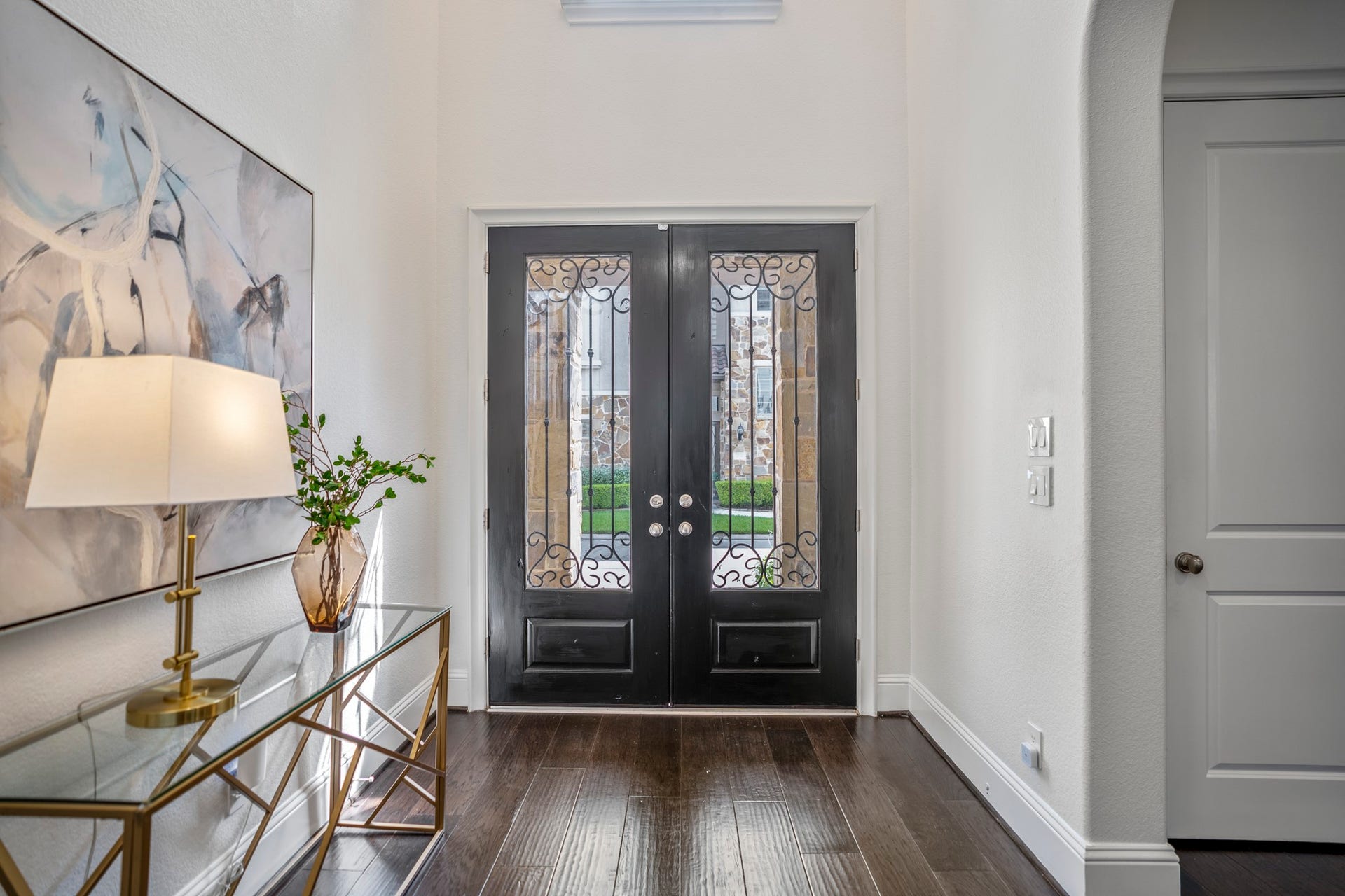 Come on in! The welcoming double-door entryway with gleaming wood floors and custom window shutters throughout leads you into the first floor living spaces, including the living room, dining area & gorgeous kitchen!