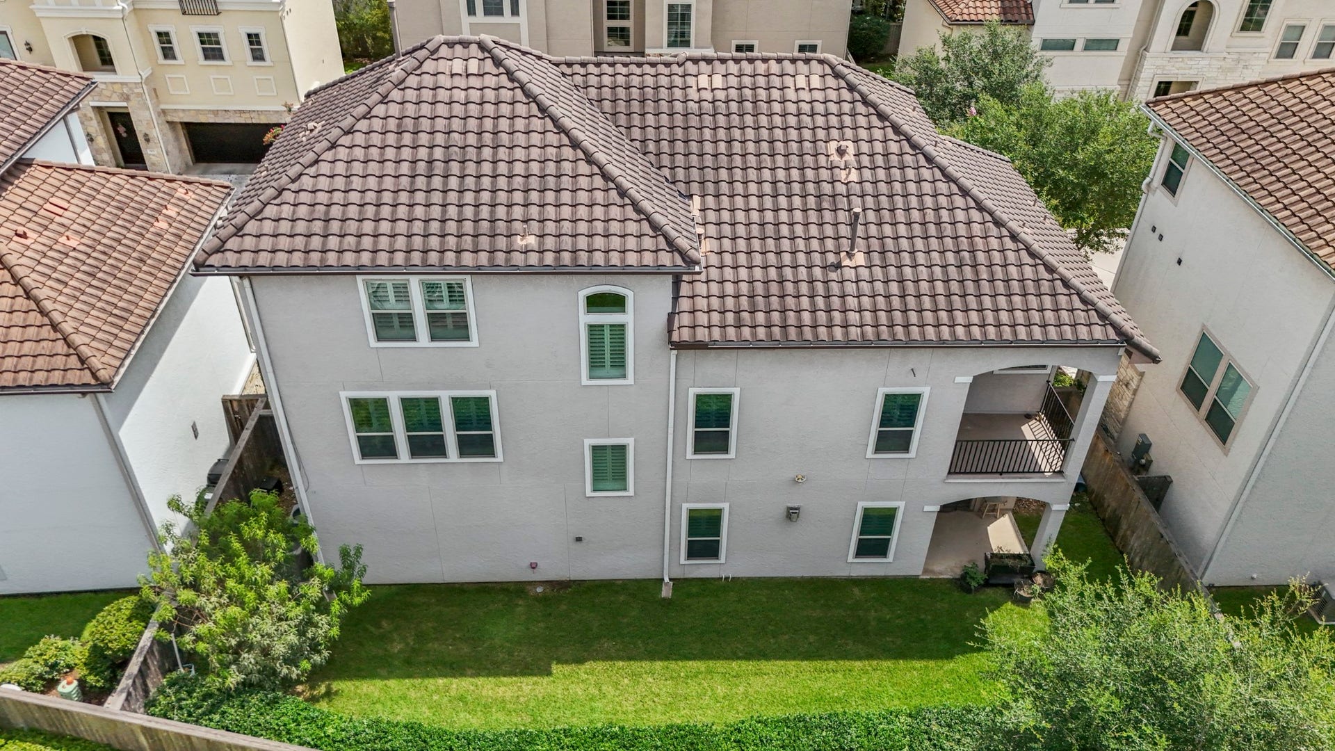 Aerial view of the backside of the home, showing a peek of the spacious backyard.