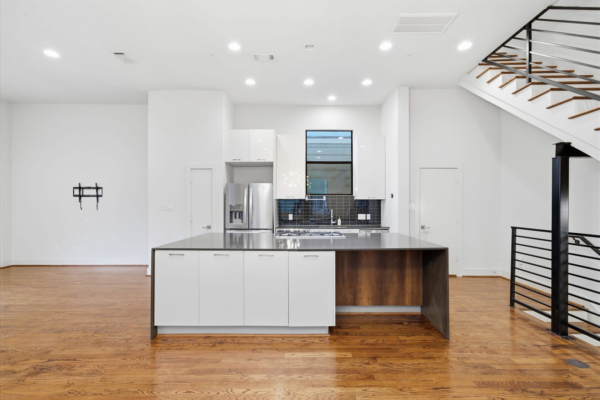 1215 Summer Street, #C, Houston, TX 77007 HUGE kitchen island with seating. All stainless steel appliances (fridge will convey). QUARTZ counters in kitchen + baths. Door on the left (next to fridge) is the pantry. Door on the right is half bath for this floor - tucked away into a corner, but still conveniently close by!
