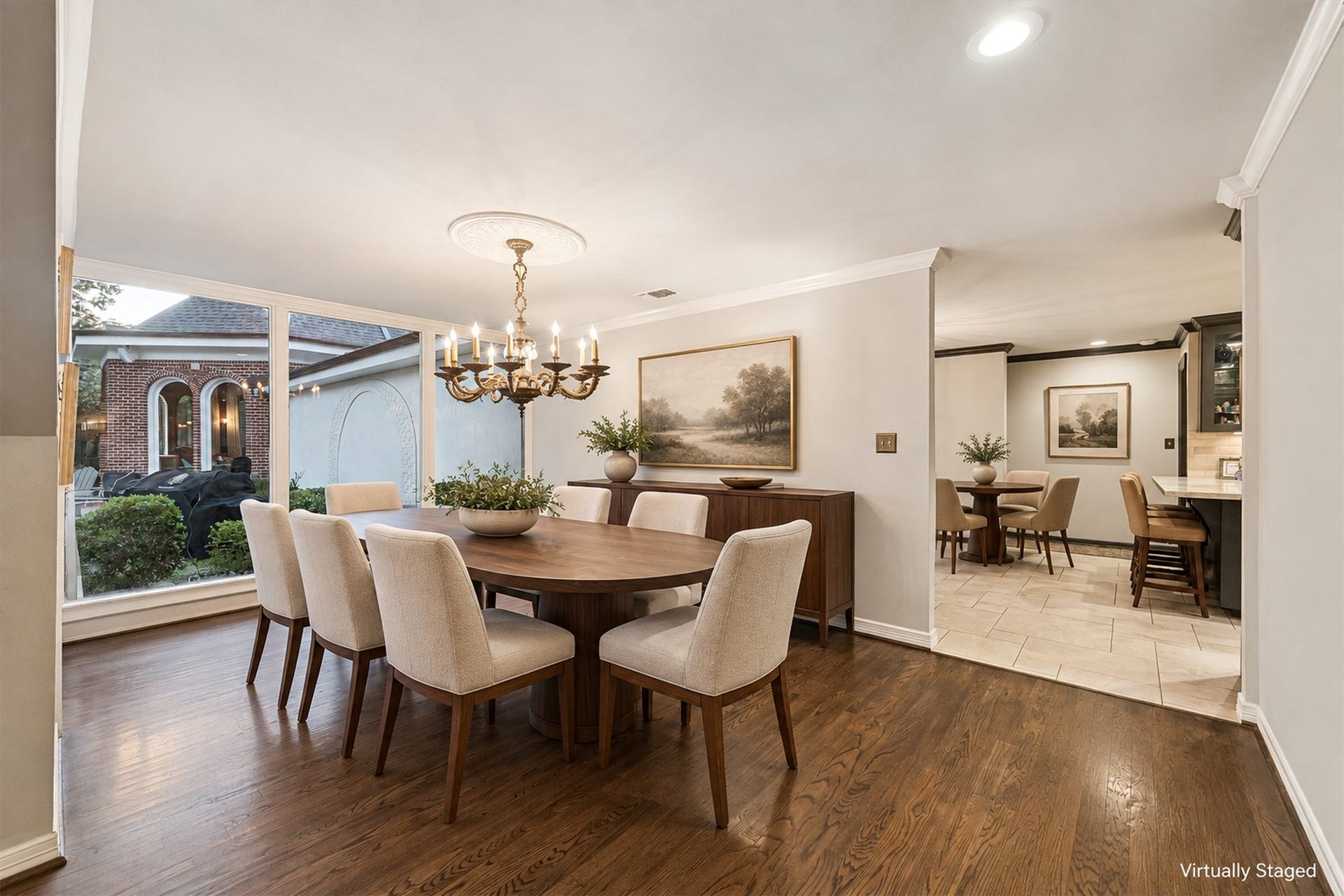 14 Stonegate Drive, Houston, TX 77024 Virtually Staged - Formal dining room features an 1850's chandelier (excluded), solid oak flooring, and large windows offering a view of the charming backyard, perfect for hosting unforgettable gatherings.