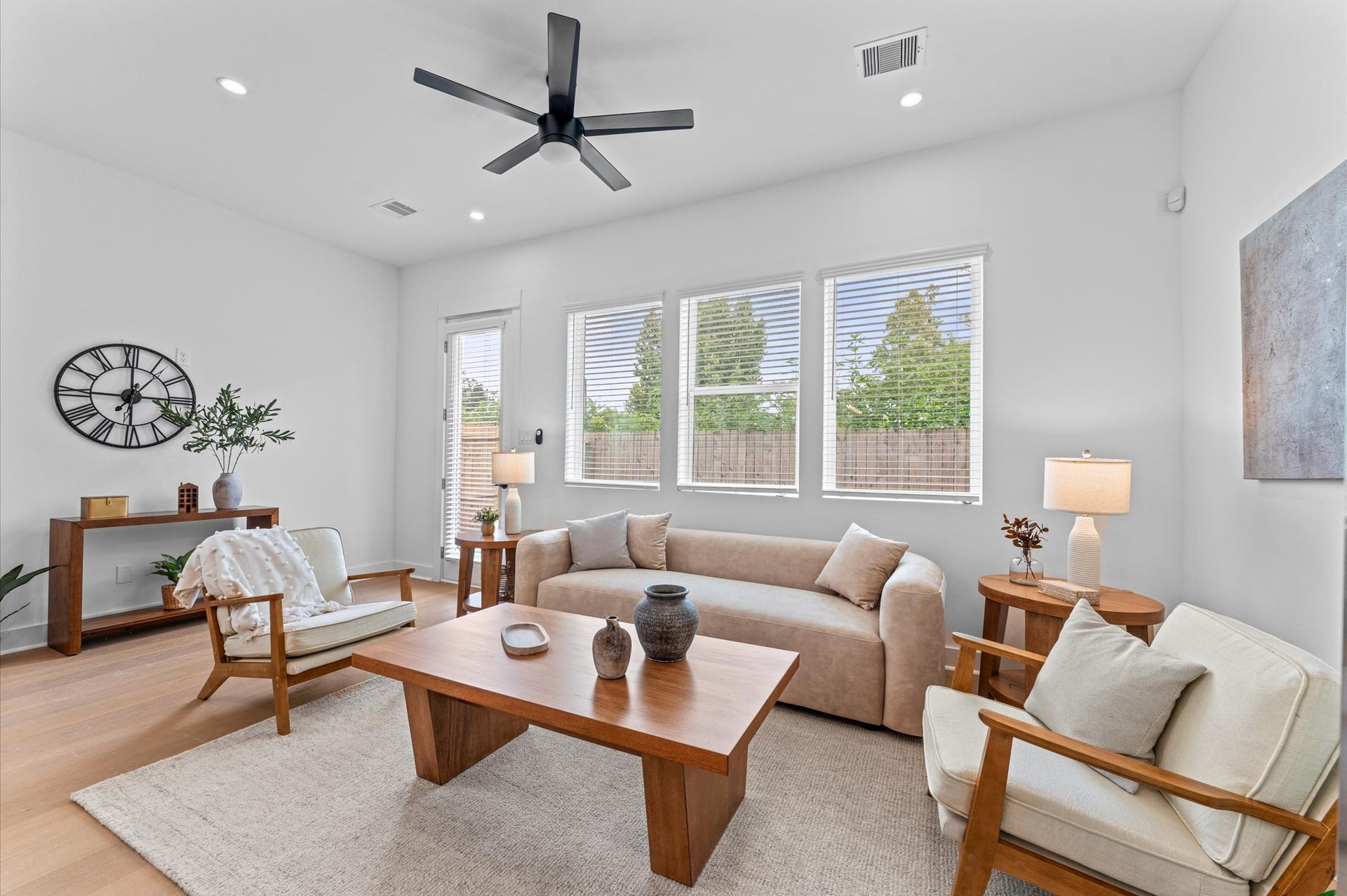 Airy and inviting open-concept living space located on the first floor, thoughtfully designed to enhance both comfort and flow. The area features high ceilings, expansive windows, and cohesive flooring that unify the living, dining, and kitchen zones.