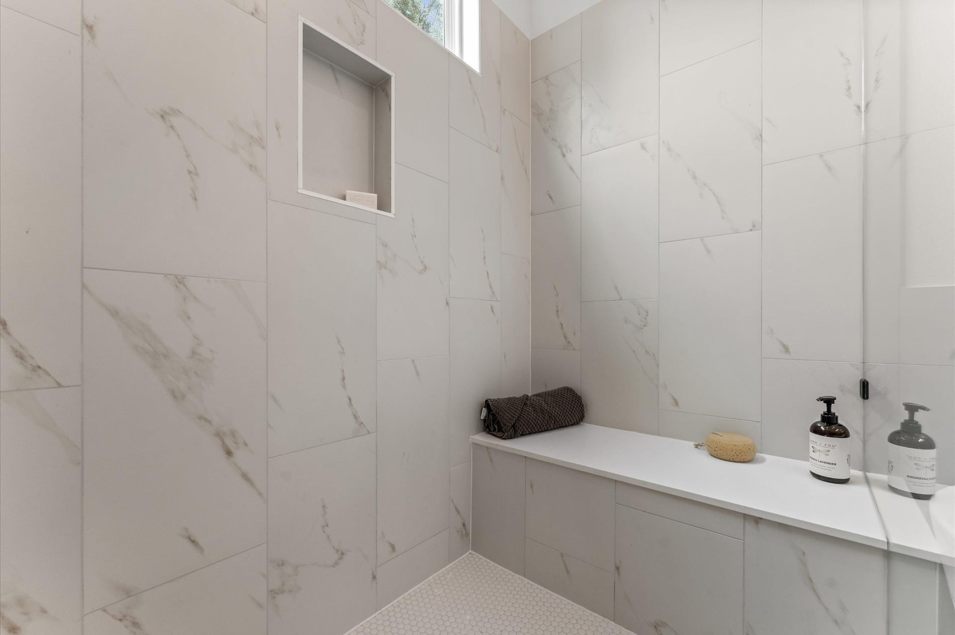 Elegant and serene primary bathroom designed to offer both style and functionality. The space features a luxurious soaking tub ideal for unwinding, a separate glass-enclosed shower for quick refreshes, and a sleek double vanity with ample countertop space and storageperfect for busy mornings or relaxing evenings.