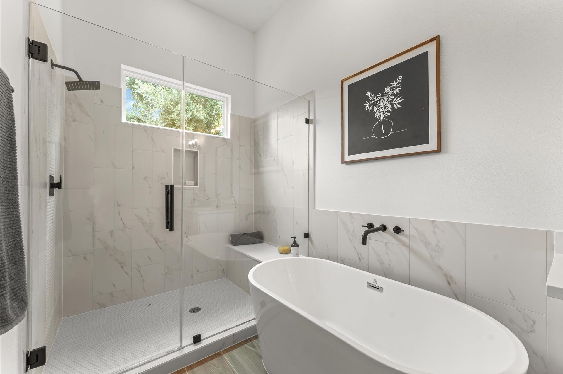 Elegant and serene primary bathroom designed to offer both style and functionality. The space features a luxurious soaking tub ideal for unwinding, a separate glass-enclosed shower for quick refreshes, and a sleek double vanity with ample countertop space and storageperfect for busy mornings or relaxing evenings.