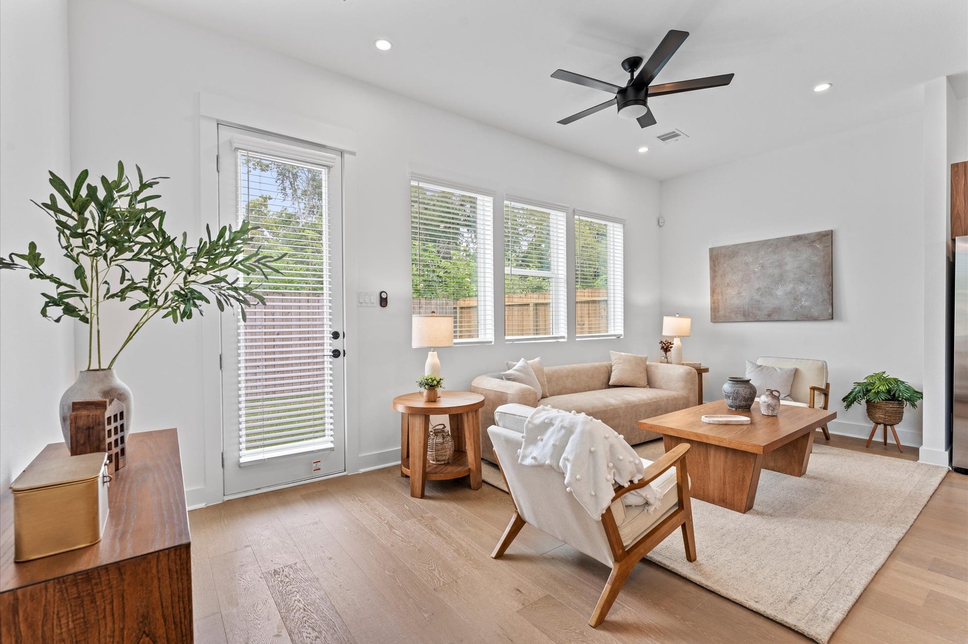 Airy and inviting open-concept living space located on the first floor, thoughtfully designed to enhance both comfort and flow. The area features high ceilings, expansive windows, and cohesive flooring that unify the living, dining, and kitchen zones.