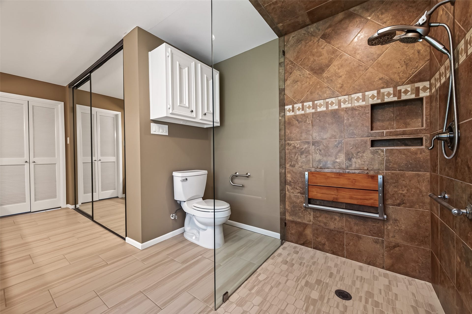 Phenomenal walk in shower with seamless glass frame, wall-mounted seat and shampoo niches! Don't miss the closet space!