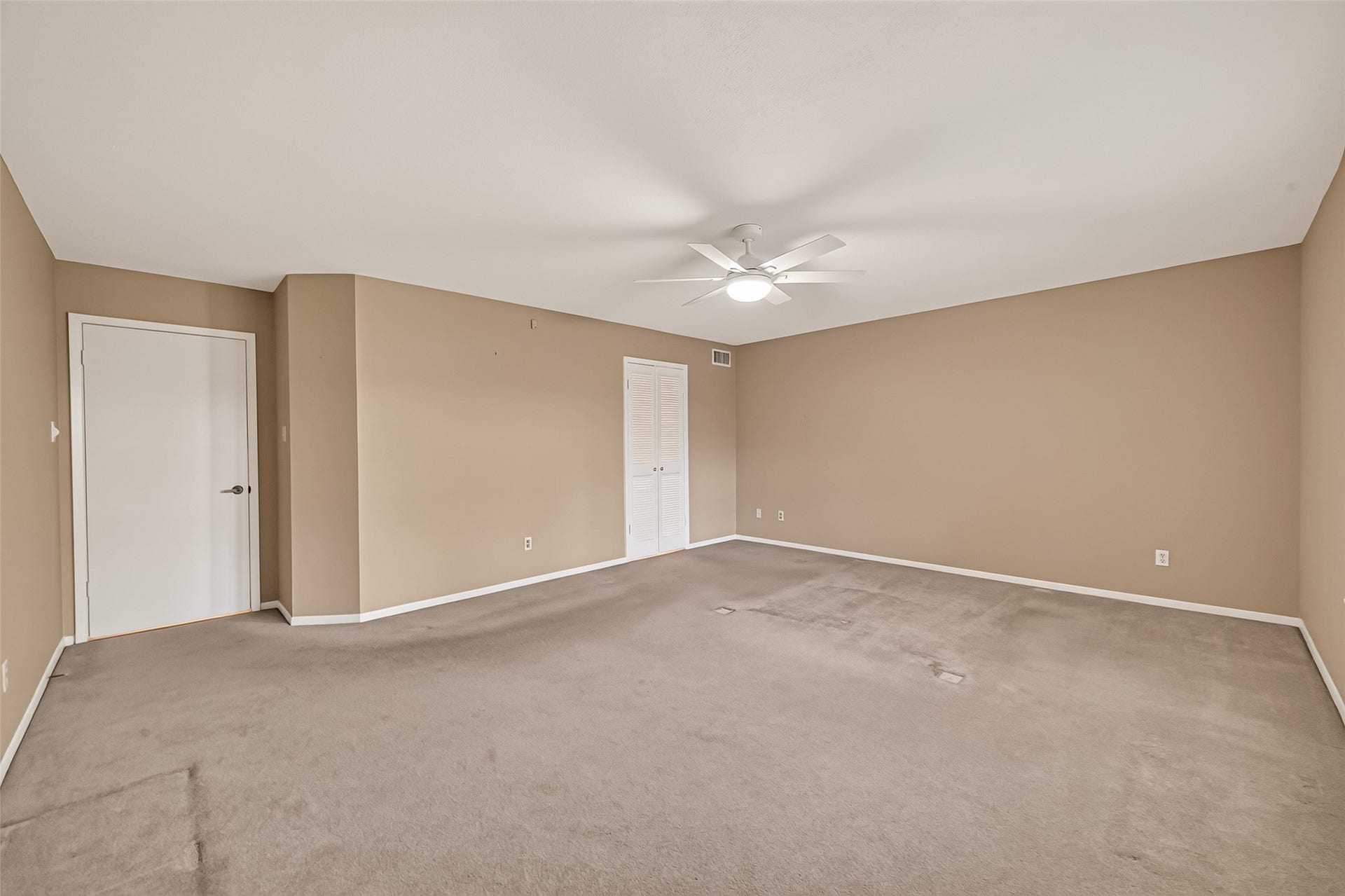 The huge primary bedroom on the 1st floor overlooks the lush backyard.