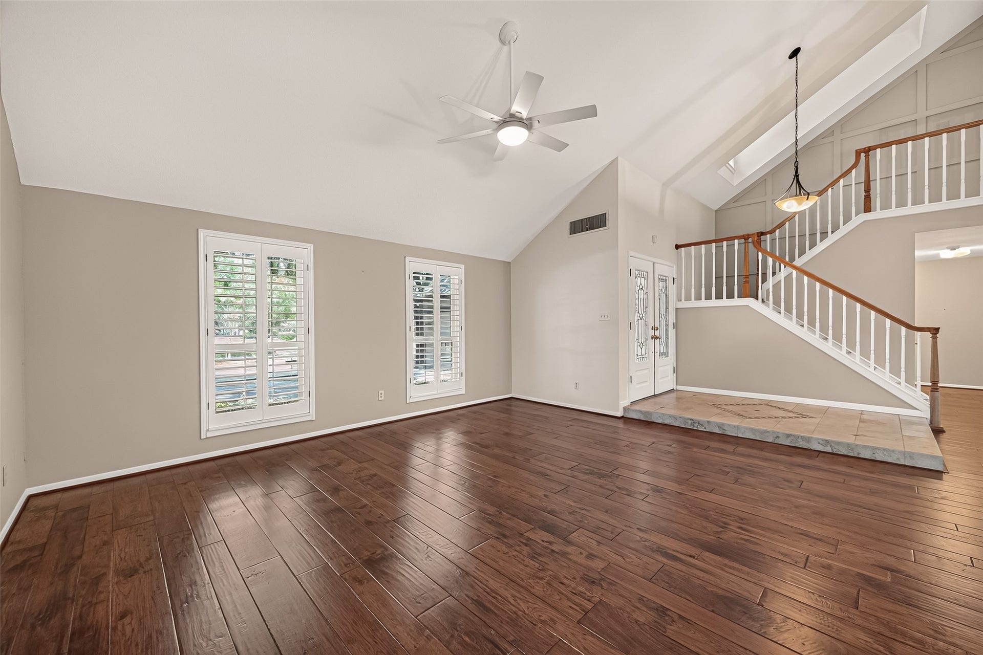 Soaring ceilings mark the large living room off entry. Gorgeous floors, wood shutters and insulated windows finish the space. Endless possibilities for furniture arrangement here and so much space for bringing friends and family together.