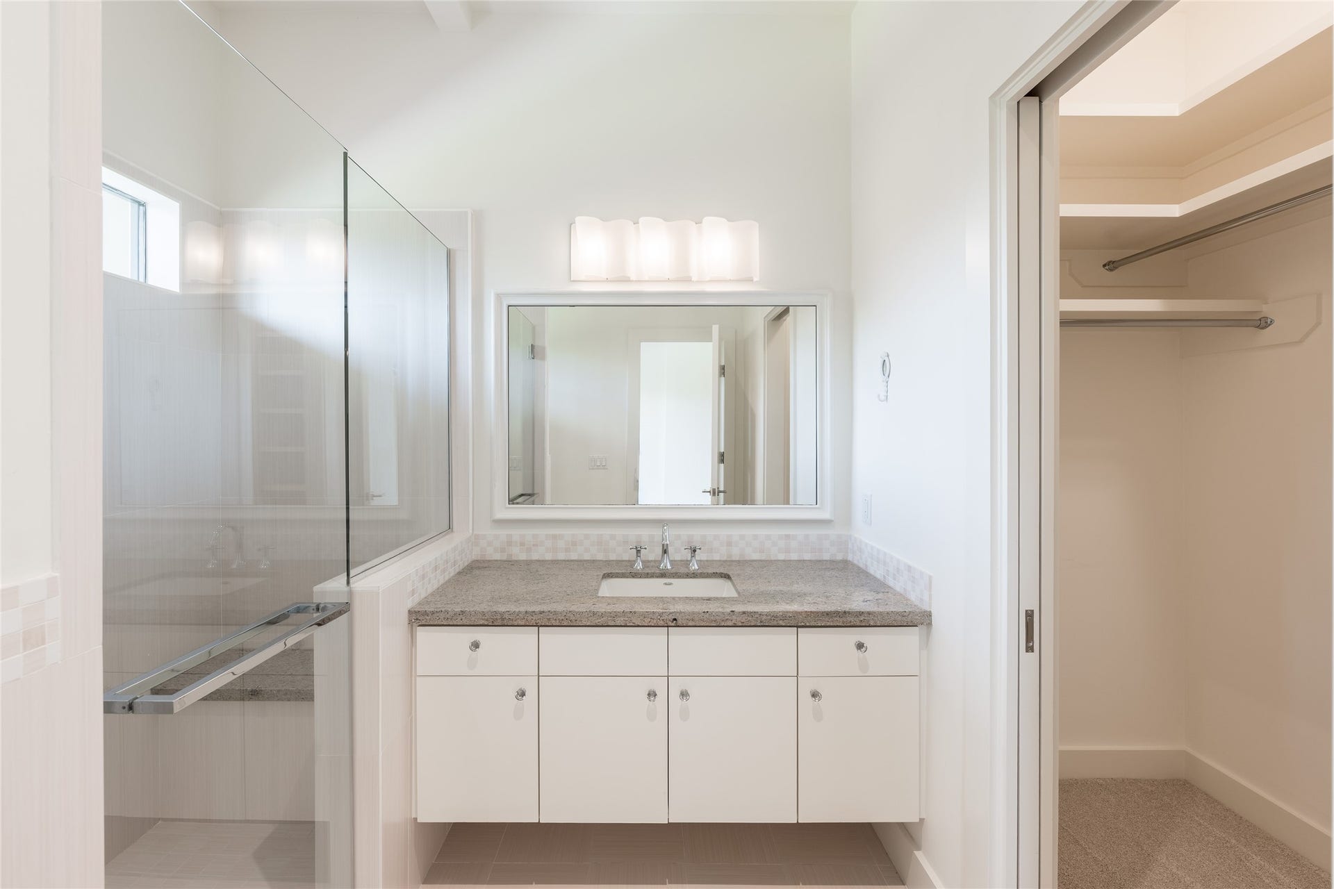 309 Glenwood Drive, Houston, TX 77007 The secondary bedroom is complete with its own private ensuite bath, featuring a floating vanity, full-width mirror, glass-enclosed walk-in shower and dedicated closet space.