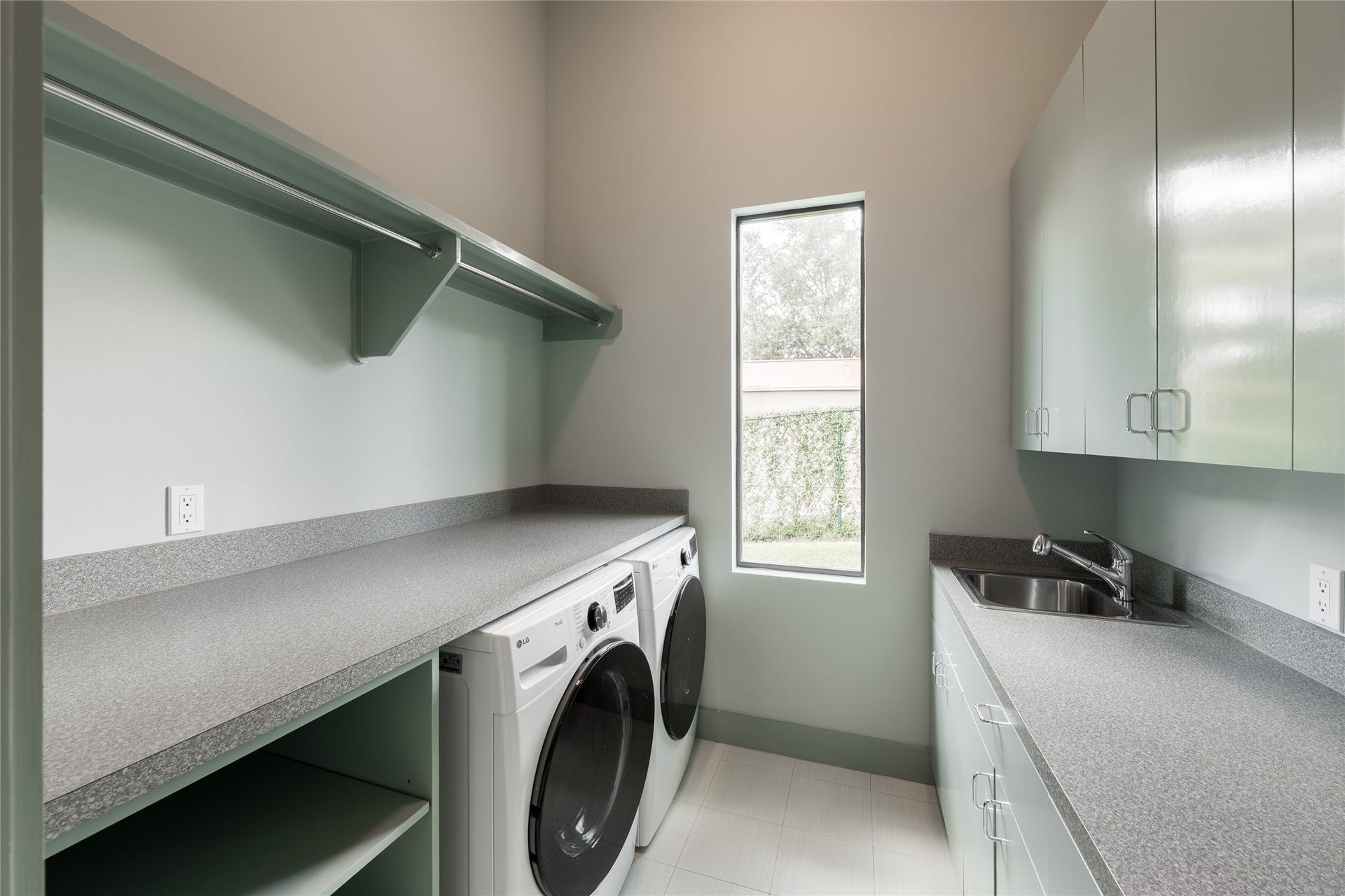 309 Glenwood Drive, Houston, TX 77007 Located on the first floor, the utility room offers generous counterspace, extensive cabinetry and open shelving for everyday organization. Dual washer and dryer units provide added capacity, while natural light keeps the workspace bright and functional.