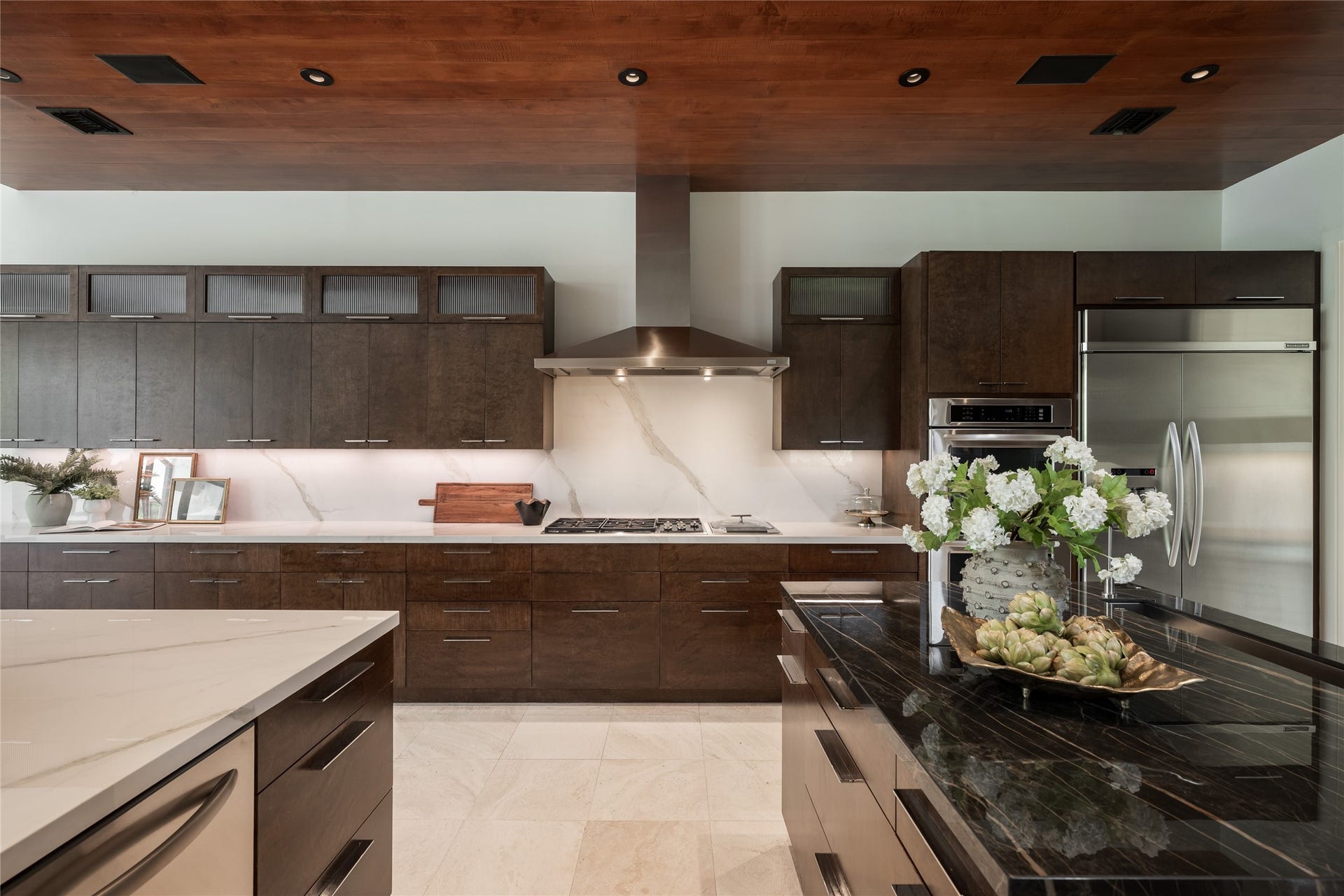 309 Glenwood Drive, Houston, TX 77007 The kitchen pairs craftsmanship with integrated technology, featuring custom LED lighting and built-in surround sound speakers throughout the kitchen. A Wolf range and double ovens, Sub-Zero refrigerator and porcelain backsplash complement the custom cabinetry.