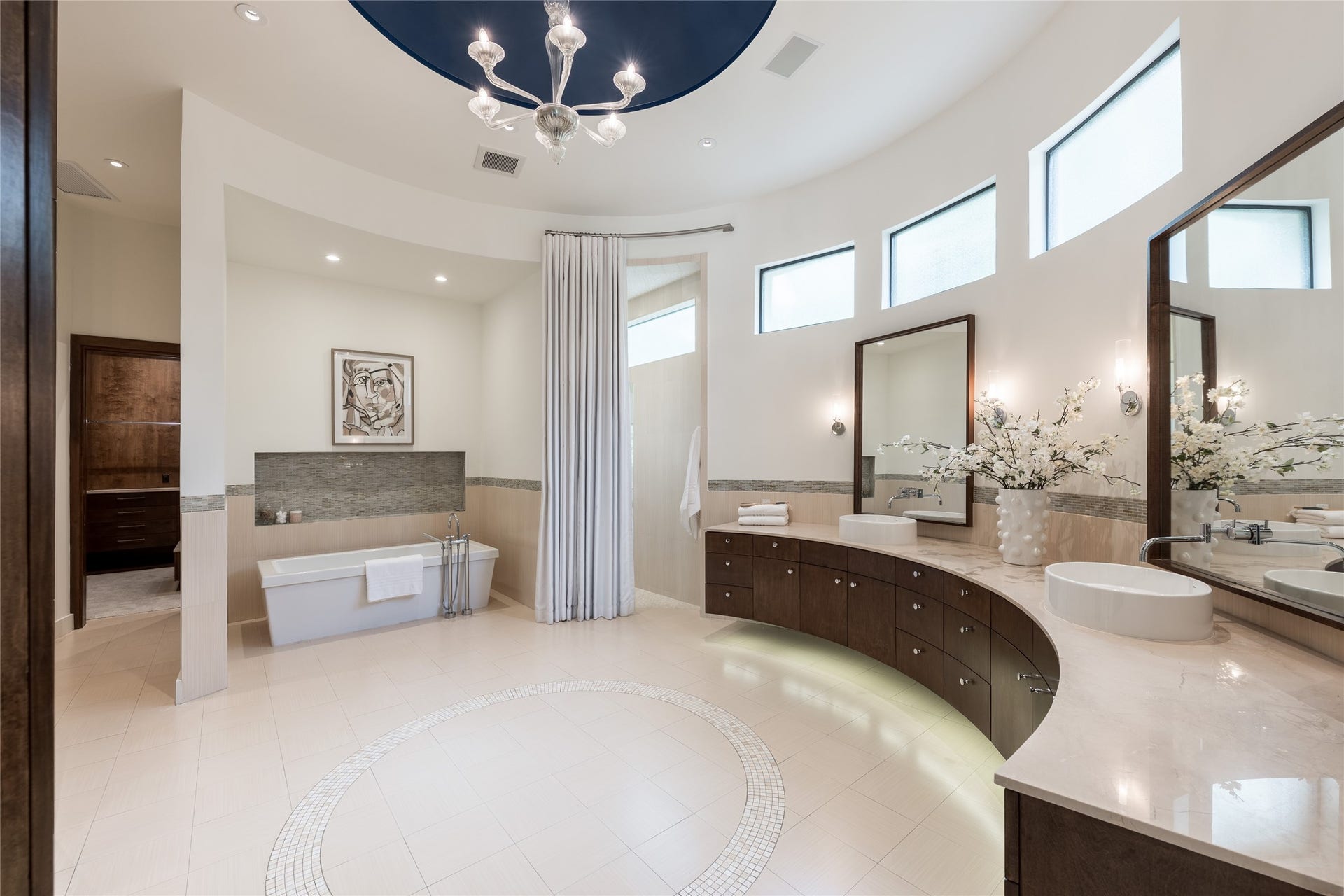 309 Glenwood Drive, Houston, TX 77007 The primary ensuite showcases custom floating curved cabinetry that follows the architecture of the room, centered by a freestanding soaking tub above a mosaic-tiled cove as an oversized walk in shower with dual showers is nestled discreetly.