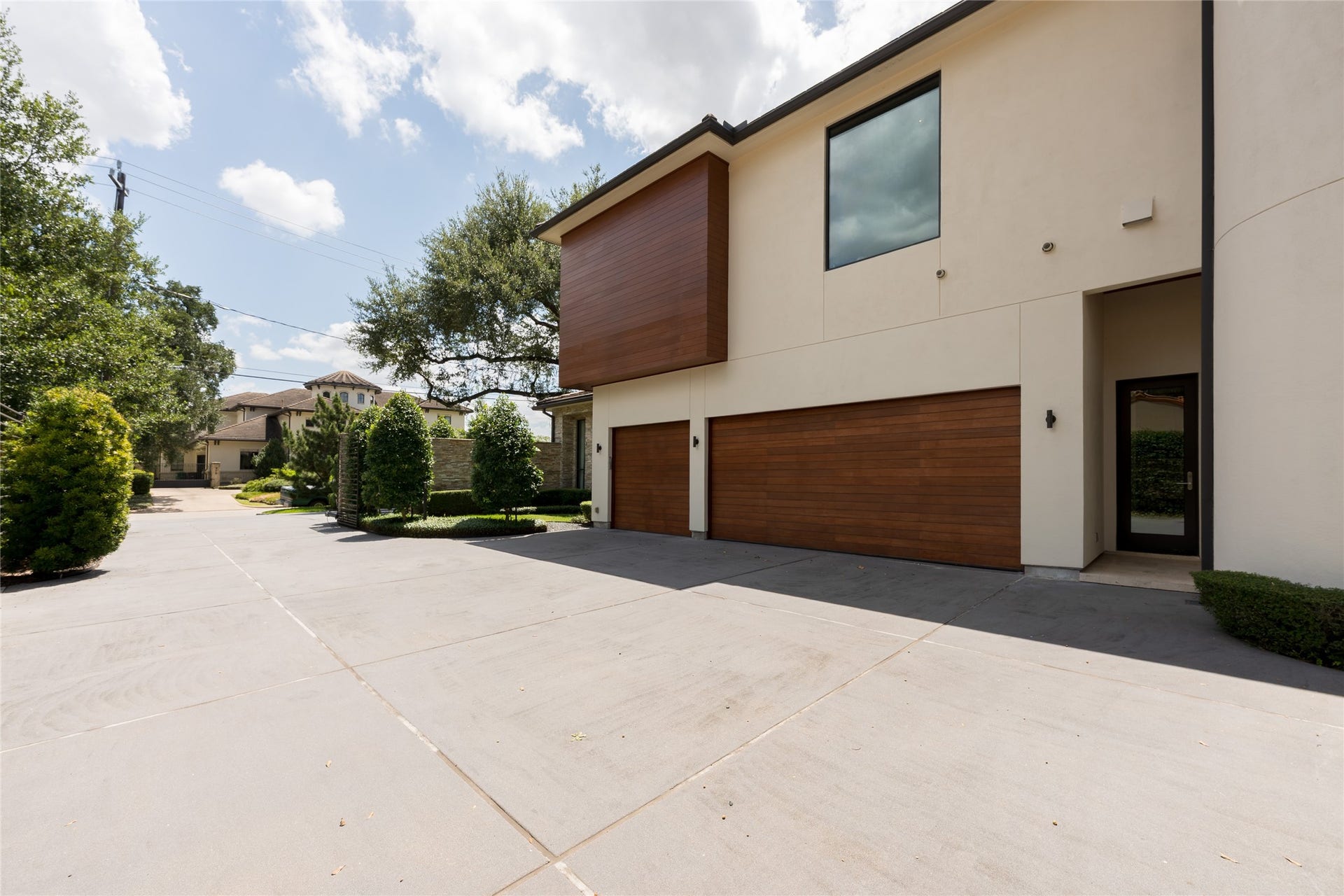 309 Glenwood Drive, Houston, TX 77007 The property offers a dedicated guest parking area before the automatic gates, with the private motor court and 3-car garage positioned beyond. This two-stage layout provides substantial parking for guests while keeping the residence and main motor court privately secured.