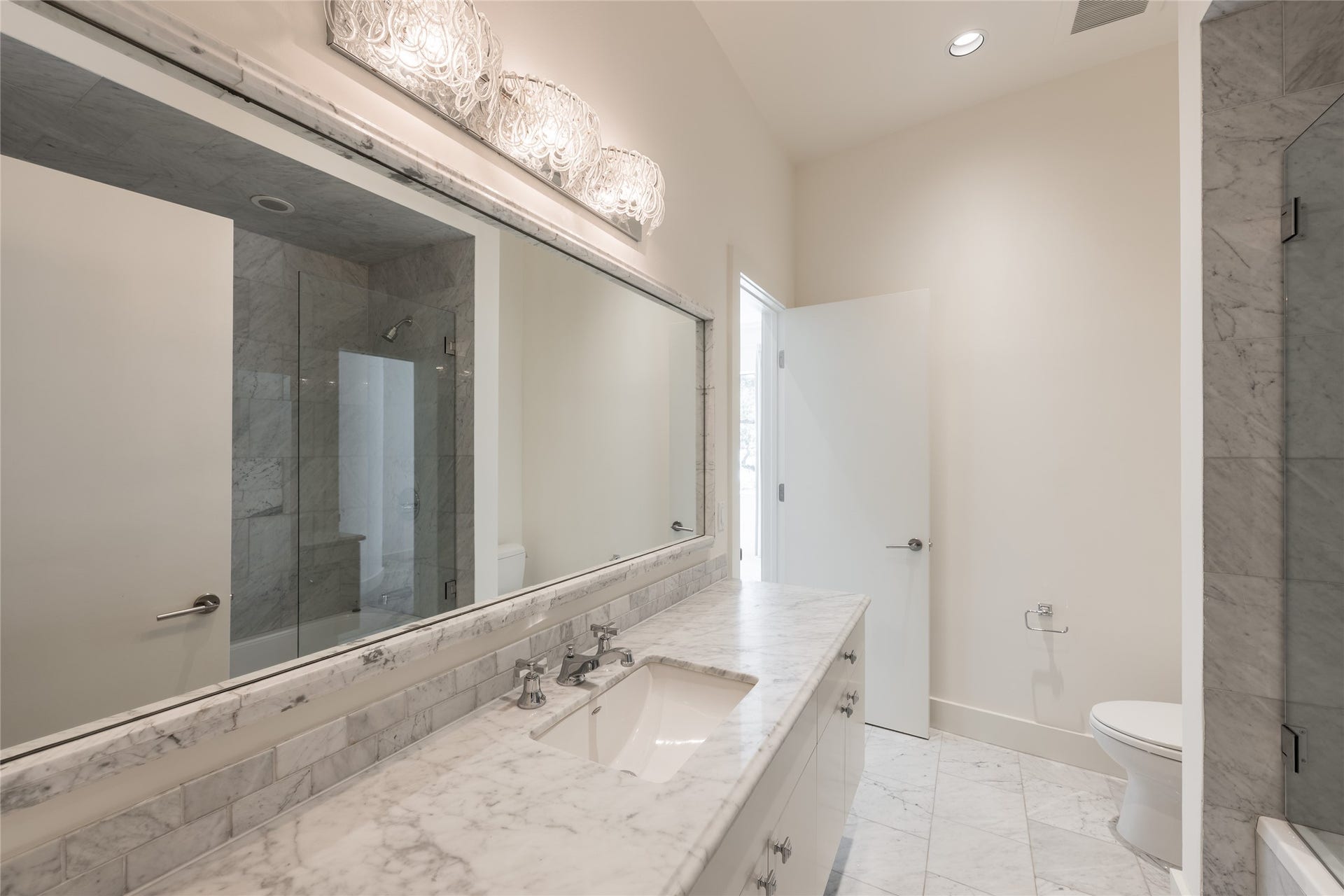 309 Glenwood Drive, Houston, TX 77007 full ensuite bath, featuring an expansive vanity with generous counterspace, a full-width mirror and a glass-enclosed walk-in shower/tub.