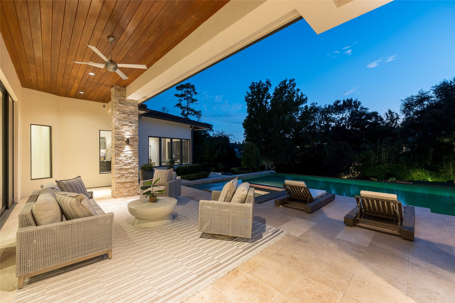 309 Glenwood Drive, Houston, TX 77007 The first-floor covered outdoor living area creates a separate lounge setting beside the heated saltwater pool, finished with a mahogany tongue-and-groove ceiling and travertine flooring. Integrated pool lighting extends the setting into the evening, while the covered space provides a direct extension of the homes indoor living areas.
