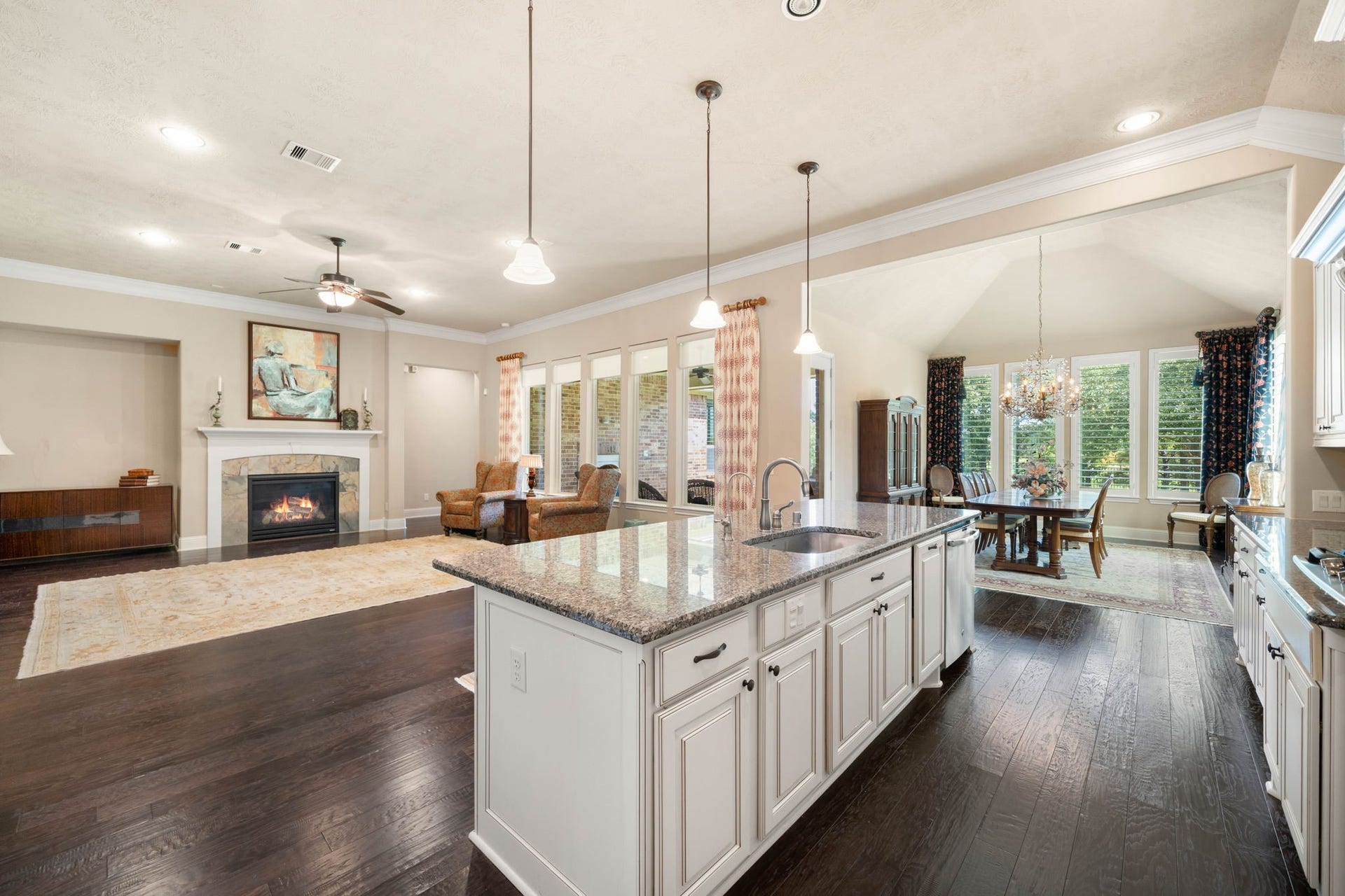 34 Edgemont Court, Fulshear, TX 77441 An open layout connects the kitchen to the living and dining areas, anchored by the home's second gas log fireplace.
