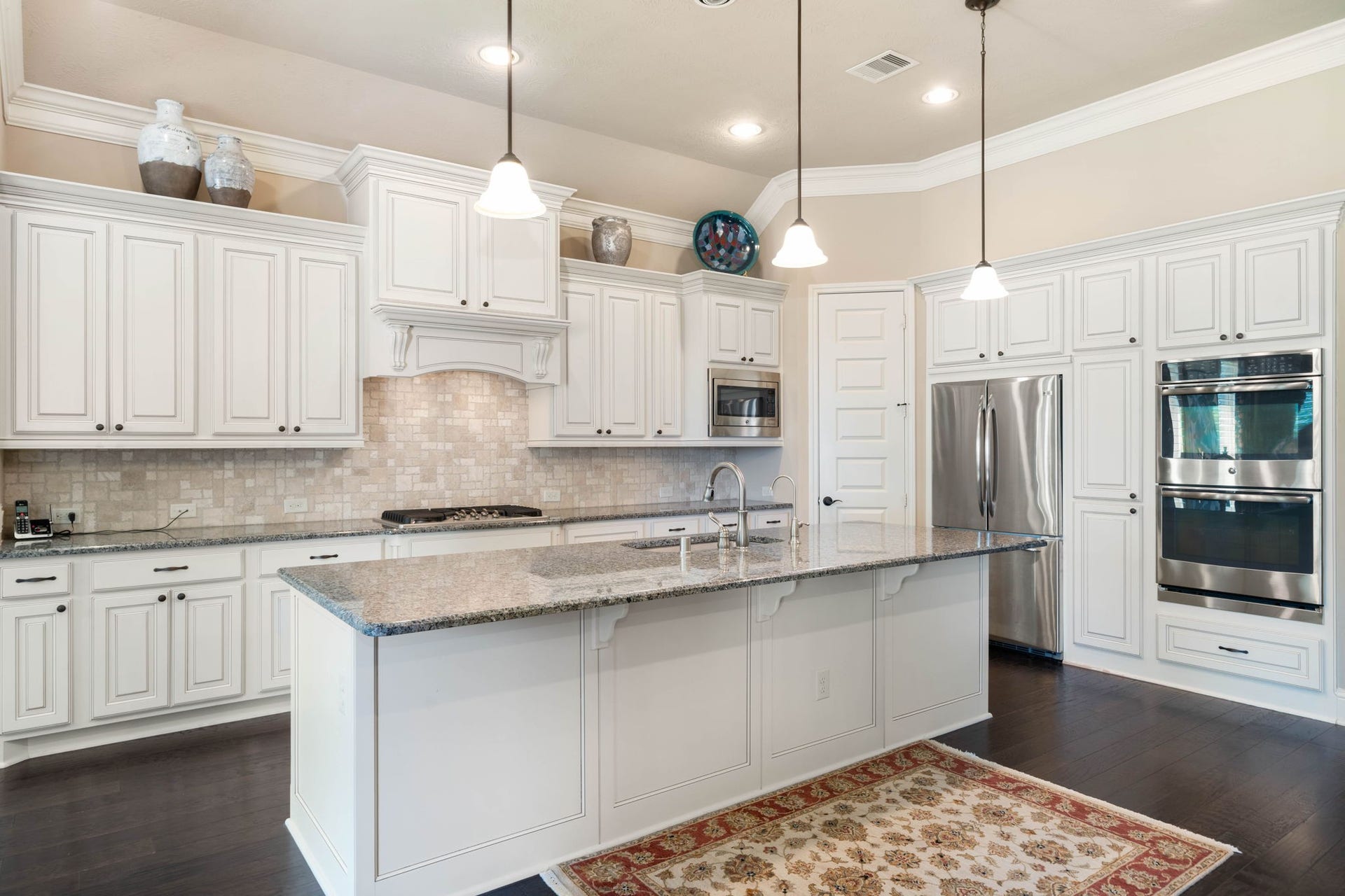 34 Edgemont Court, Fulshear, TX 77441 The kitchen is a showstopper, featuring granite countertops, a spacious island, and stainless steel double ovens.