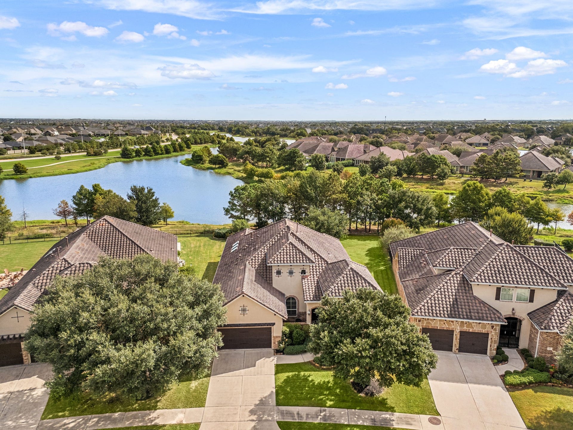 34 Edgemont Court, Fulshear, TX 77441 This bird's-eye perspective showcases the home's setting on a spacious lot, just steps from the community's scenic lake.
