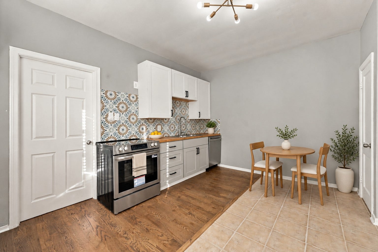 5129 Claremont Street, Houston, TX 77023 Unit 1 Kitchen with oak wood floors and tile with stainless steel appliances. Virtually staged.