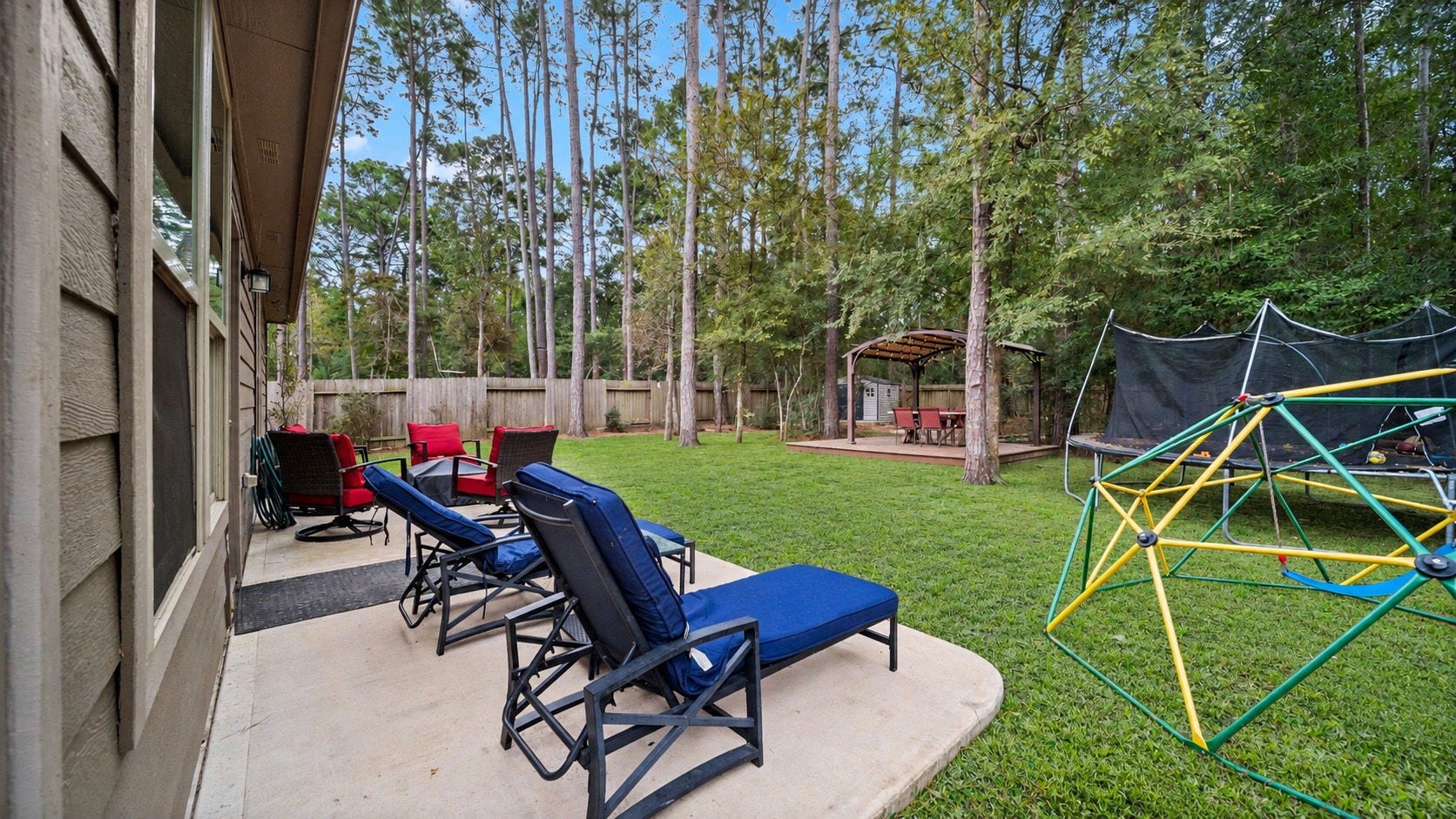 4170 Hidden Timbers Lane, Conroe, TX 77304 our own backyard retreat! Enjoy a spacious, fully fenced yard surrounded by beautiful mature trees, with plenty of room to relax and enjoy the outdoors. Outdoor furniture, trampoline, and climbing structure not included.