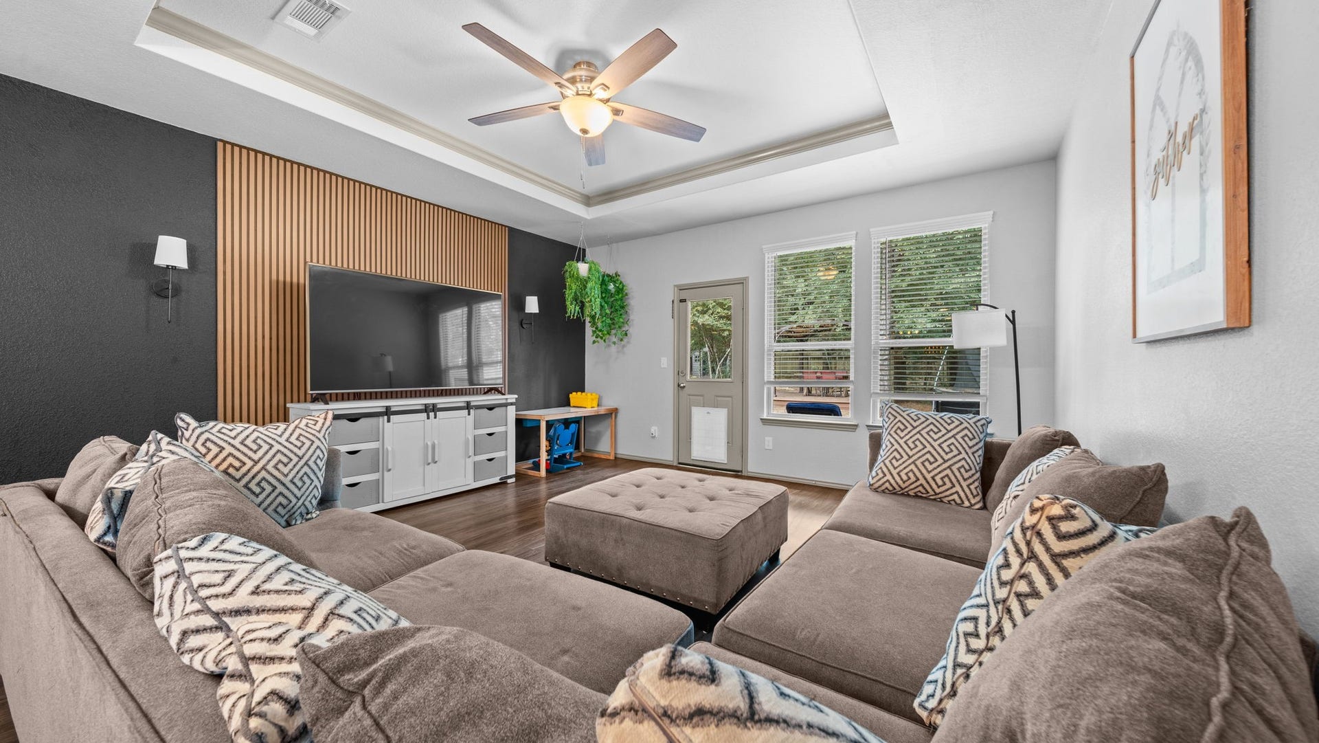 4170 Hidden Timbers Lane, Conroe, TX 77304 Fall in love with this inviting living room! A recessed tray ceiling and stunning specialty wood-slat accent wall create a stylish space to relax or entertain.Enjoy convenient backyard access through the living room, complete with a dog door that staysan added bonus for your four-legged companion!