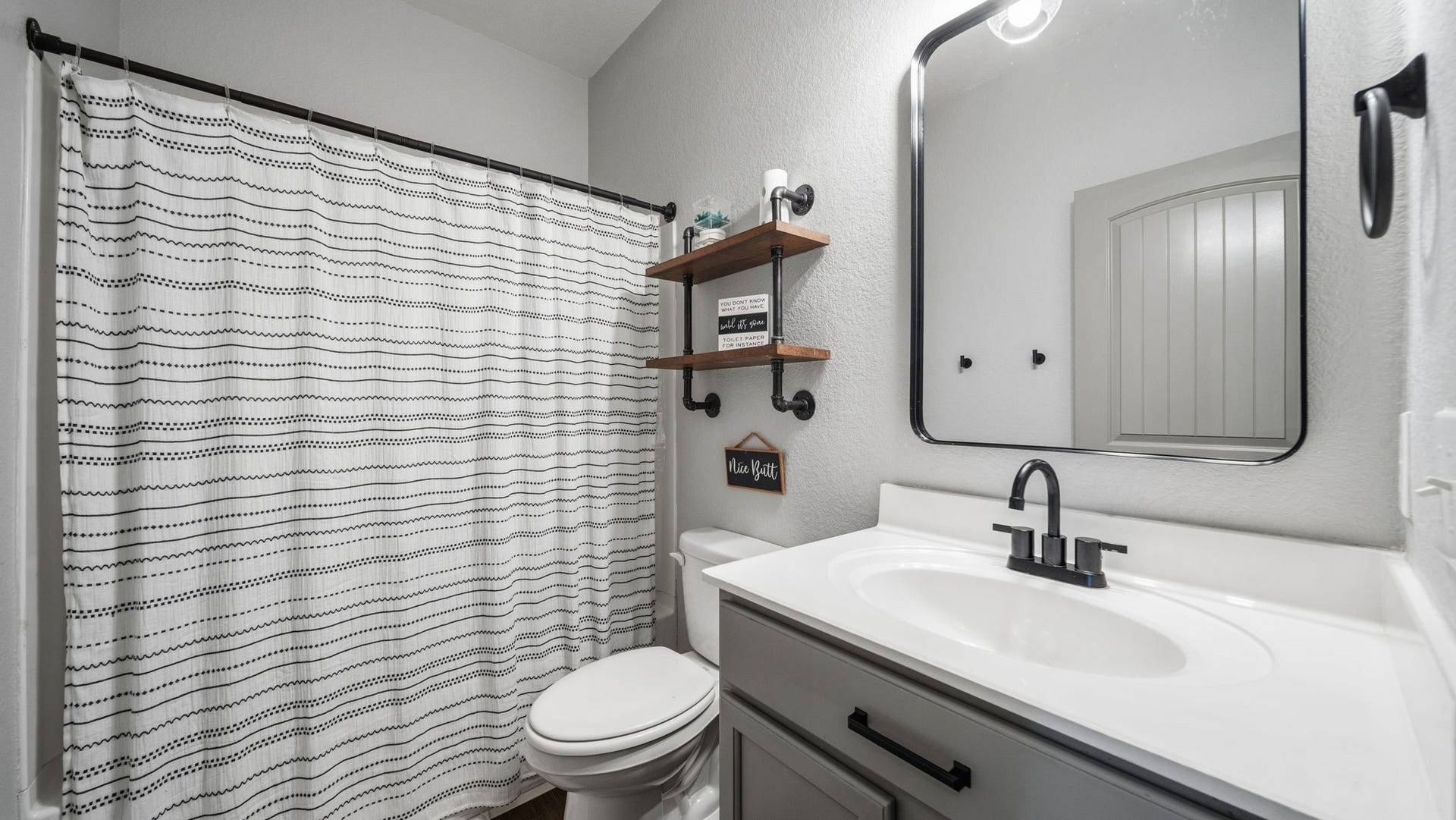 4170 Hidden Timbers Lane, Conroe, TX 77304 Fresh, inviting bathroom featuring an updated vanity, modern black fixtures, and a convenient tub/shower combination.