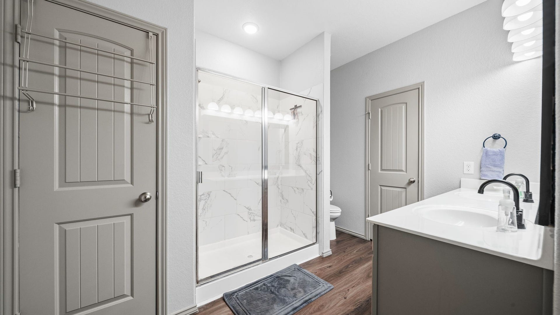 4170 Hidden Timbers Lane, Conroe, TX 77304 Your private retreat! The main primary bathroom features a spacious walk-in shower with beautiful marble-look tile and a modern vanity.