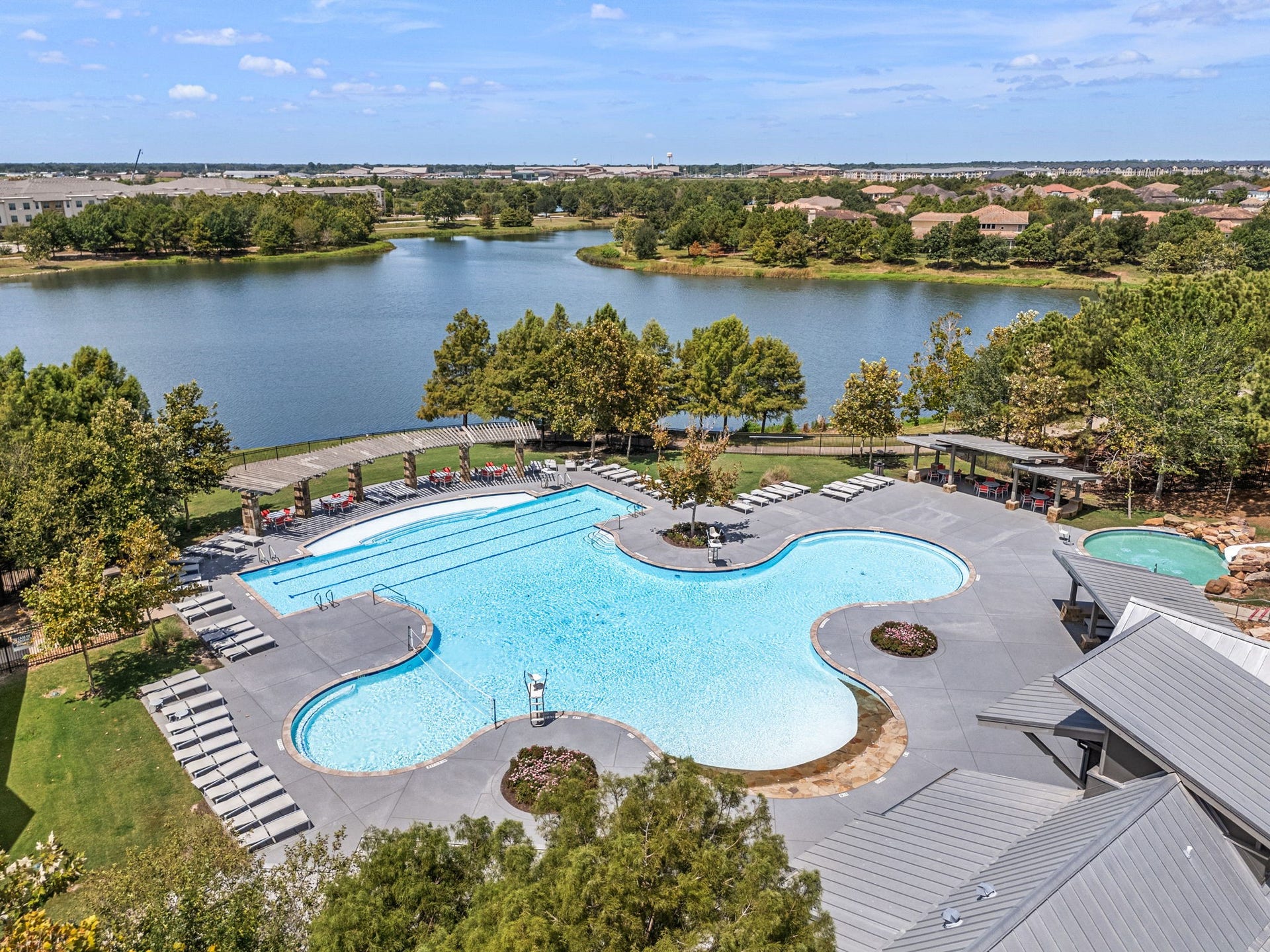 34 Edgemont Court, Fulshear, TX 77441 Adventure Island Waterpark in Cross Creek Ranch in Fulshear features an expansive resort-style pool with dedicated lap lanes, tanning shelves with water jets, a wading pool, and an iconic 140-foot waterslide, all set beside a scenic community lake.