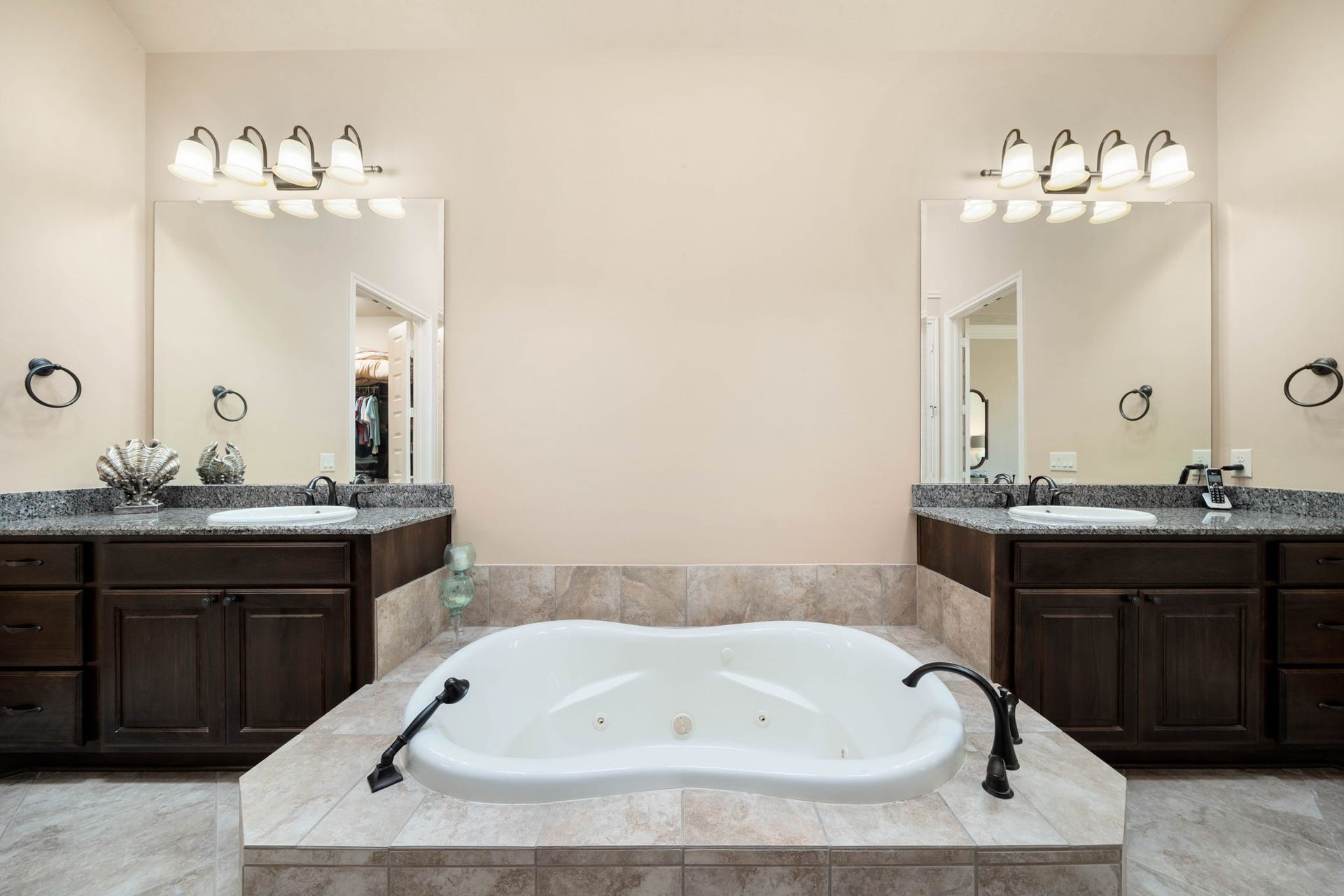 34 Edgemont Court, Fulshear, TX 77441 The primary bath offers a spa-like escape, featuring a jetted garden tub flanked by dual vanities with granite countertops.