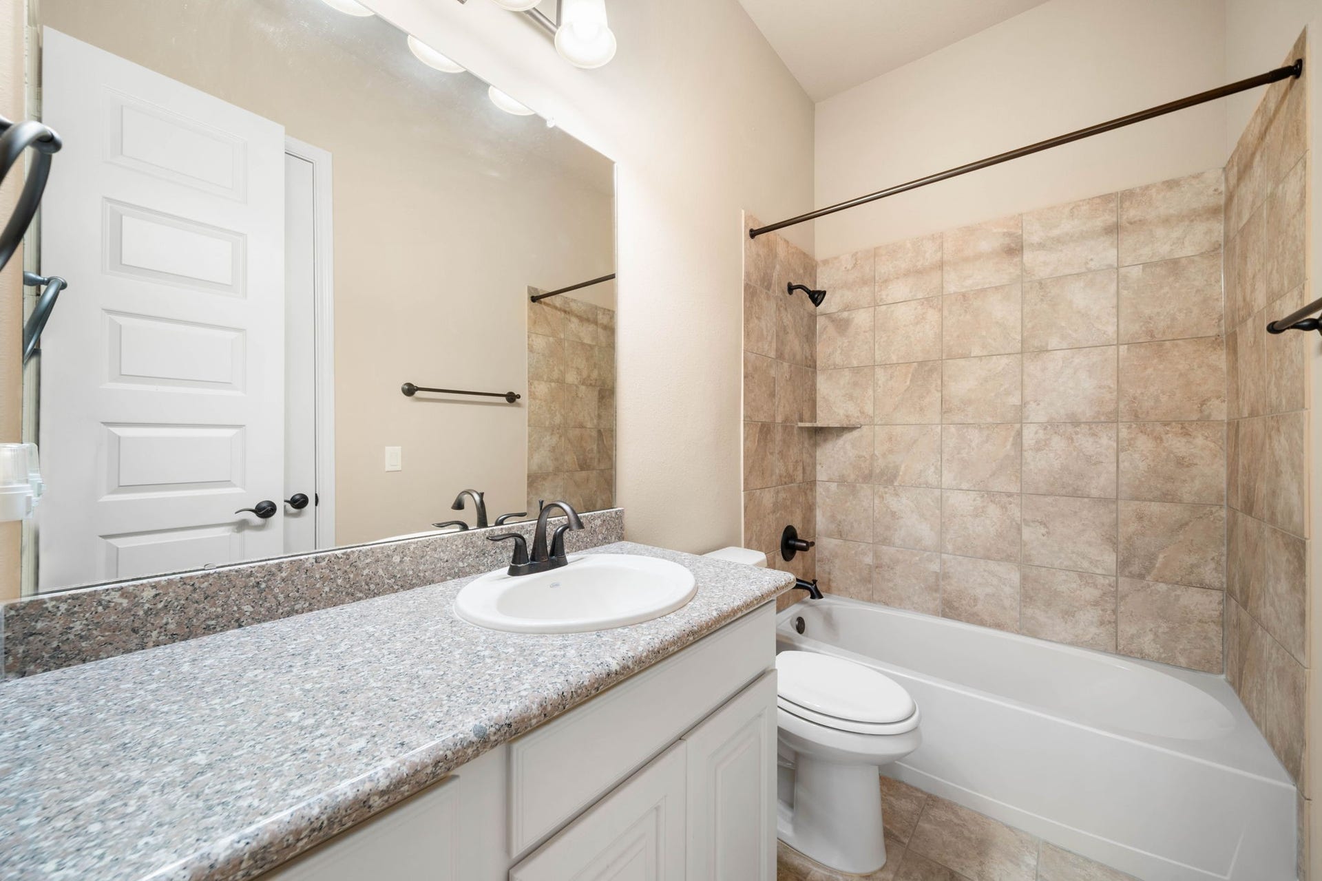 34 Edgemont Court, Fulshear, TX 77441 The secondary bathroom features granite countertops and a tub/shower combo finished with tile surround.