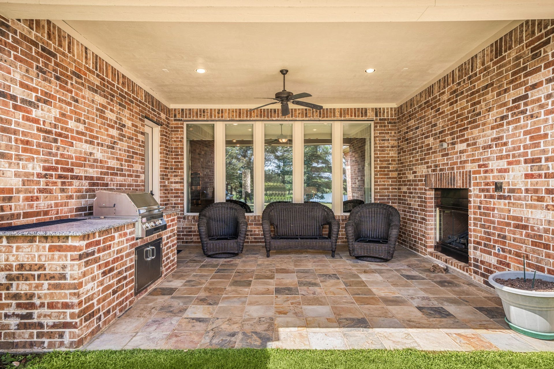 34 Edgemont Court, Fulshear, TX 77441 The covered patio is built for entertaining, complete with an outdoor kitchen, a gas log fireplace, and a ceiling fan for year-round comfort.
