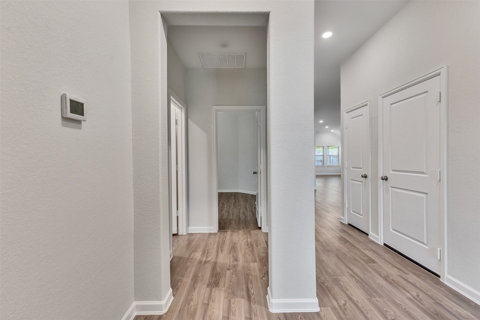Entry foyer featuring fresh neutral paint, vinyl plank flooring, high ceilings, and recessed lighting.