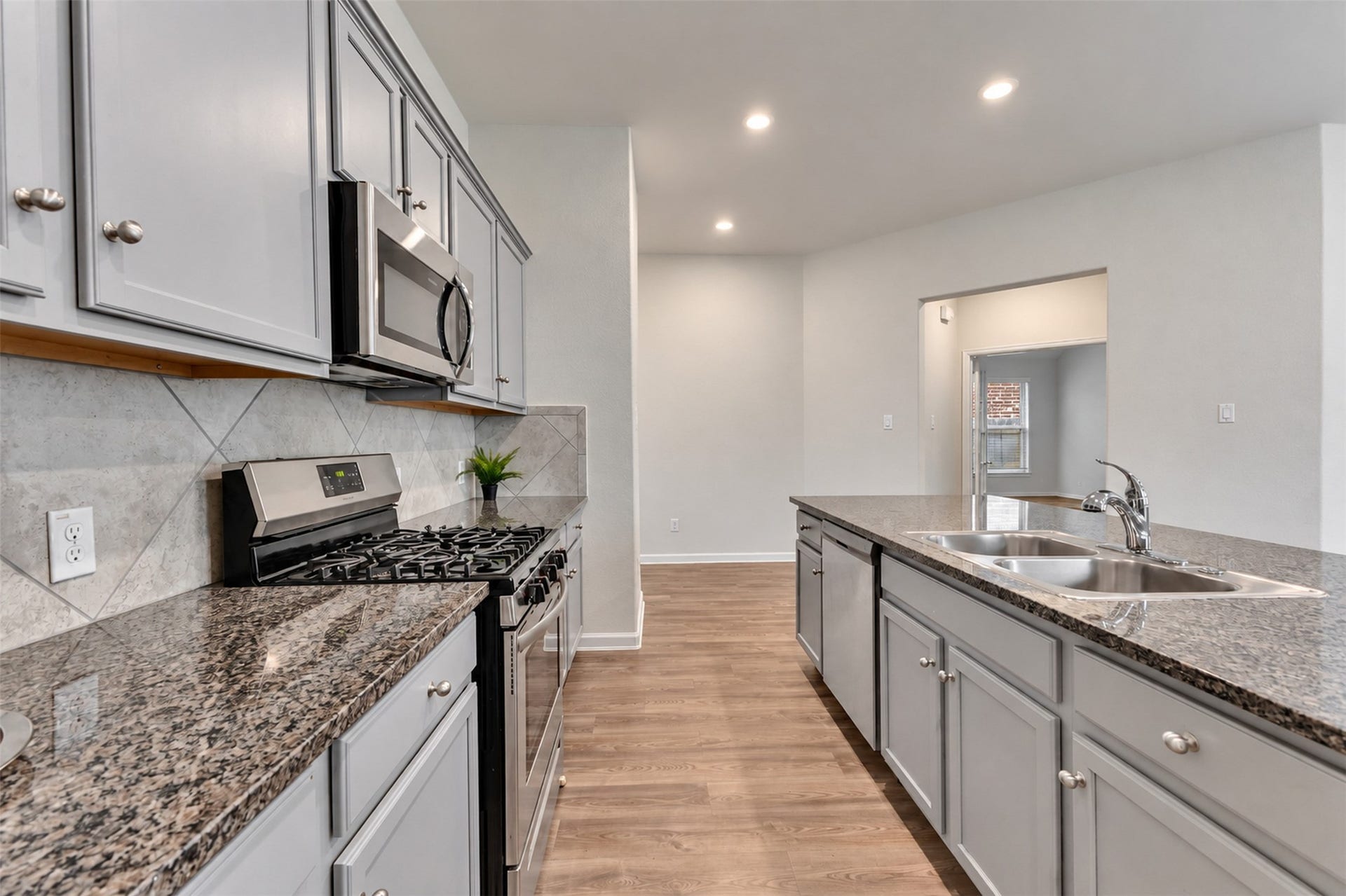 Kitchen view showcasing granite countertops, stainless steel appliances, abundant cabinetry, and spacious countertop workspace.