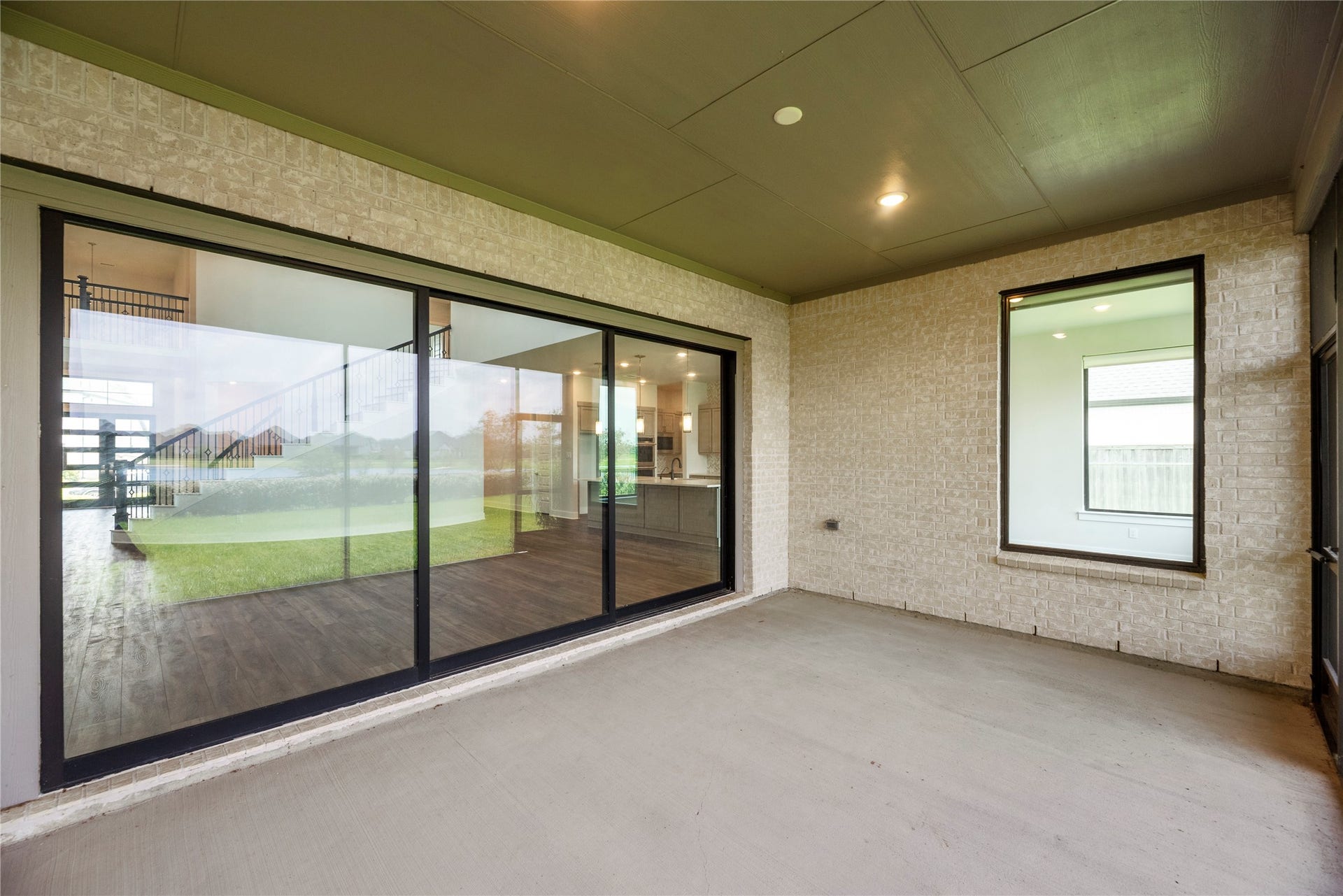 Expansive multi-panel sliding glass door connects the spacious covered porch directly to the main interior living area.