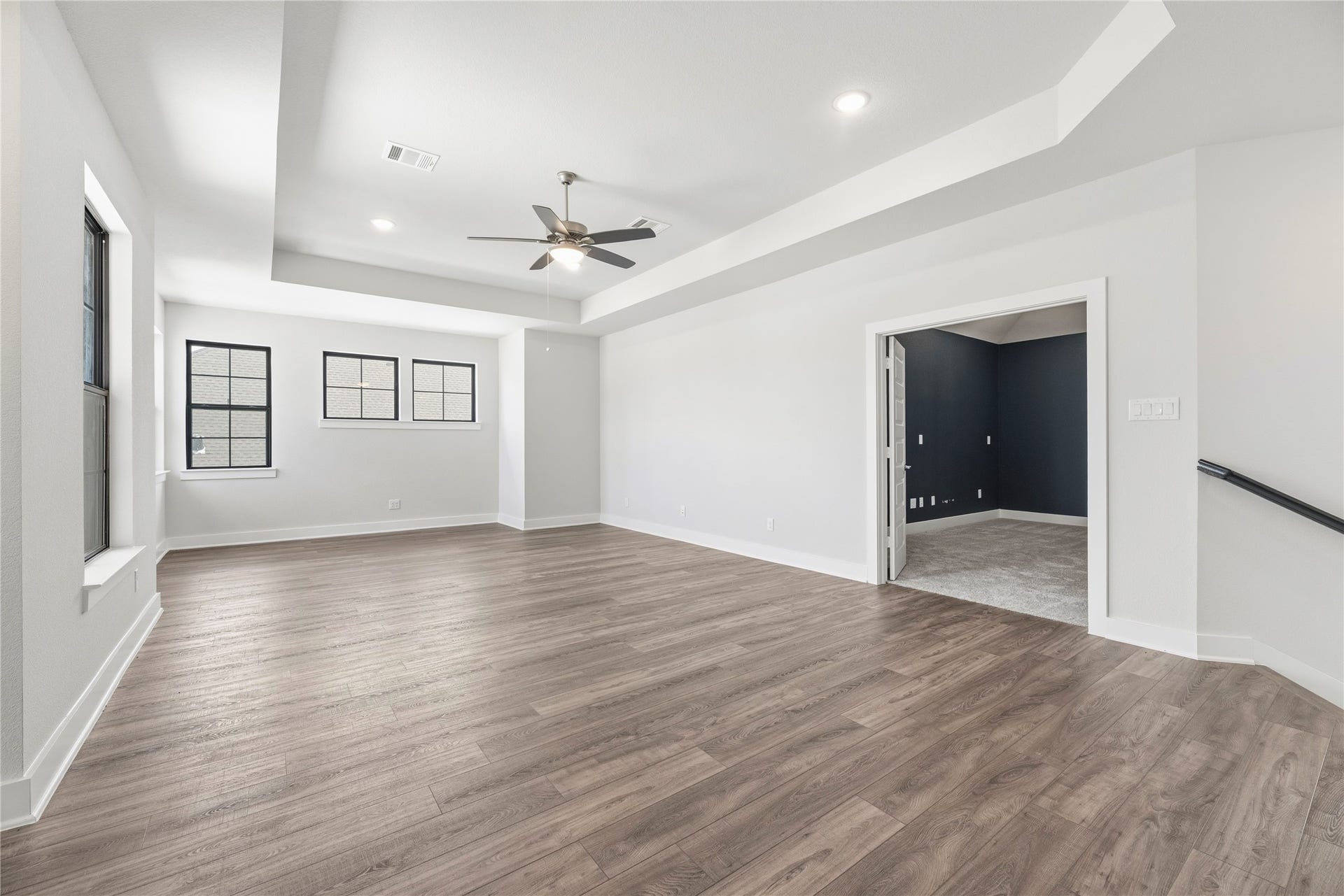 Open layout showing the seamless transition between the main upstairs living area and the adjacent flex/media room through elegant French doors.