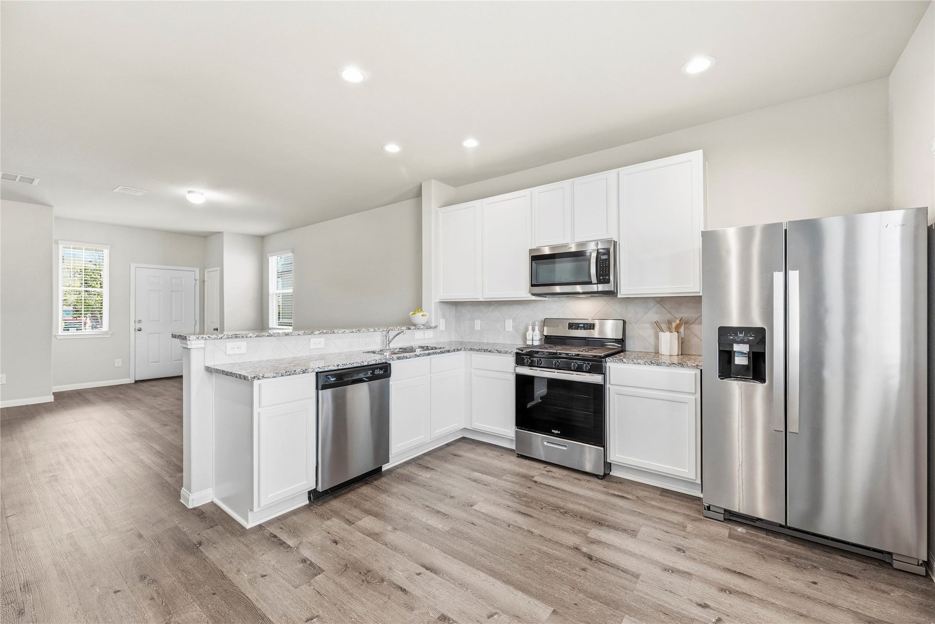 2276 Raider Drive, Conroe, TX 77301 Kitchen with granite counters and stainless appliances. Refrigerator included.