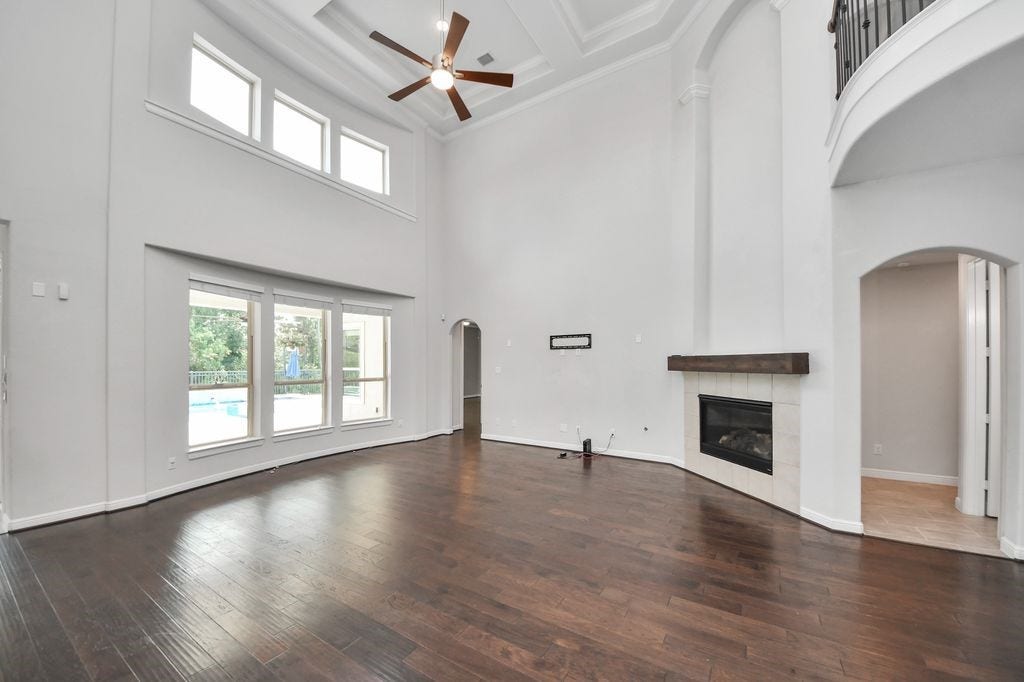 4035 Ashland Woods Drive, Spring, TX 77386 This family room is amazing! High ceilings, designer fan, gas log fireplace, & open to the kitchen and breakfast room. Great views of the pool/spa and greenbelt behind.