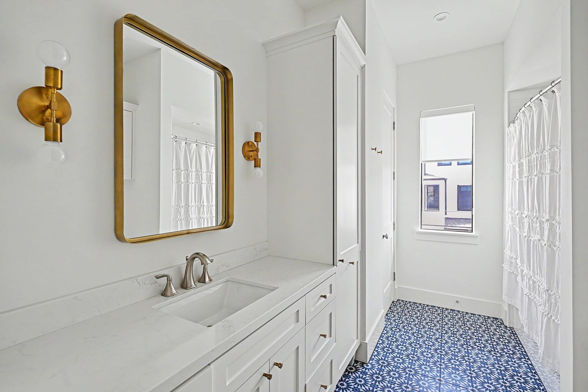 1605 Mcduffie Street, Houston, TX 77019 Full secondary bathroom features elegant brass accents and thoughtfully selected tilework.