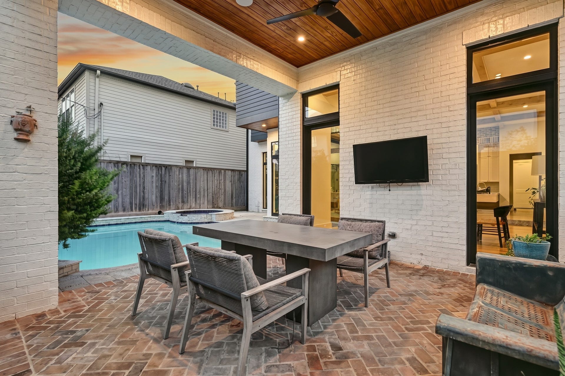 1605 Mcduffie Street, Houston, TX 77019 The covered patio features a warm wood ceiling and ample room for outdoor dining beside the pool.