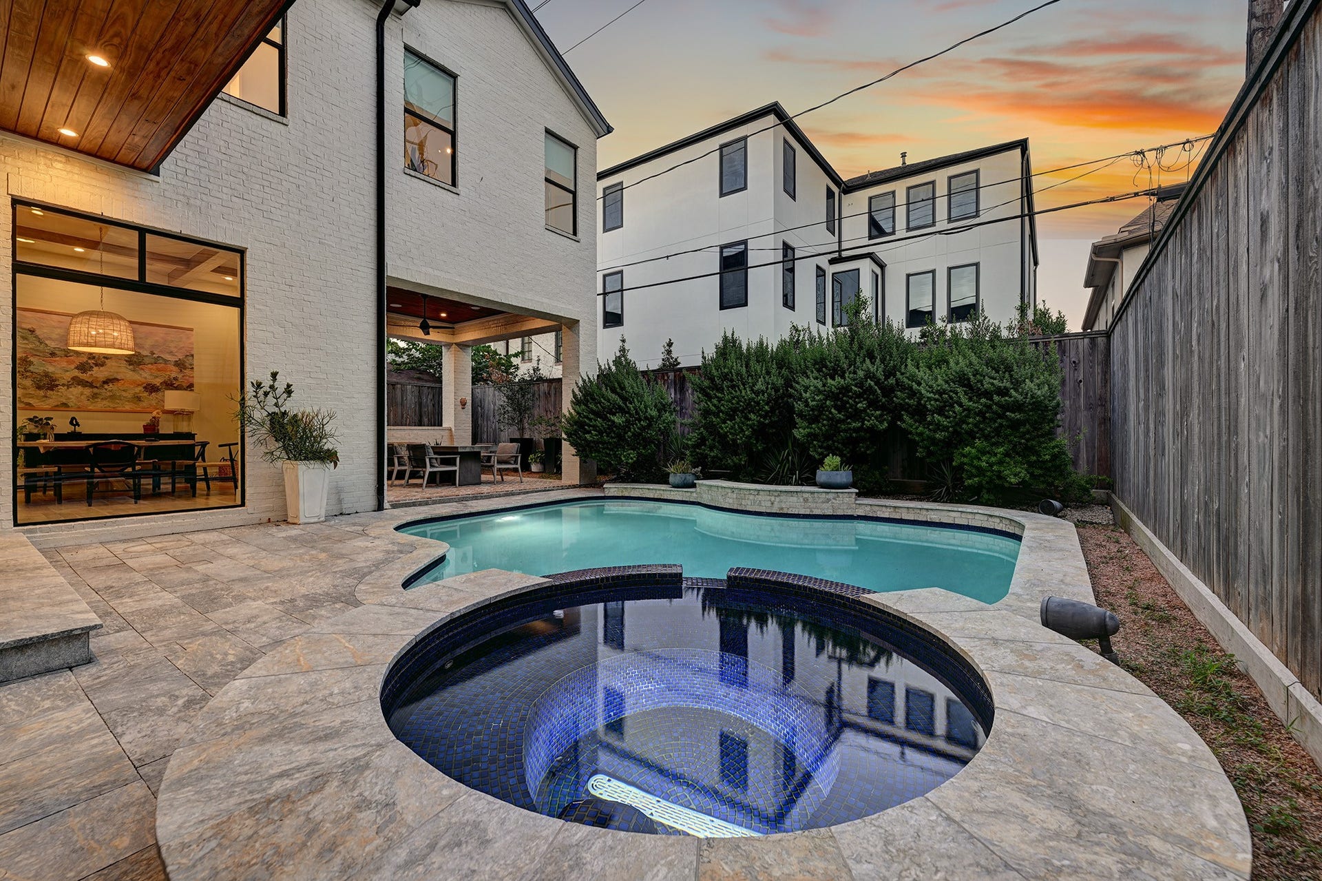 1605 Mcduffie Street, Houston, TX 77019 An evening view captures the pool, spa and beautifully designed backyard entertaining space.