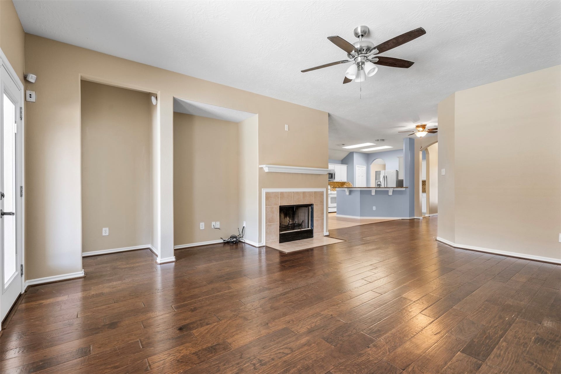 12902 Cascadia Knoll Court, Humble, TX 77346 Open-concept living area showcasing the fireplace, and direct sightline into the kitchen and breakfast bar.