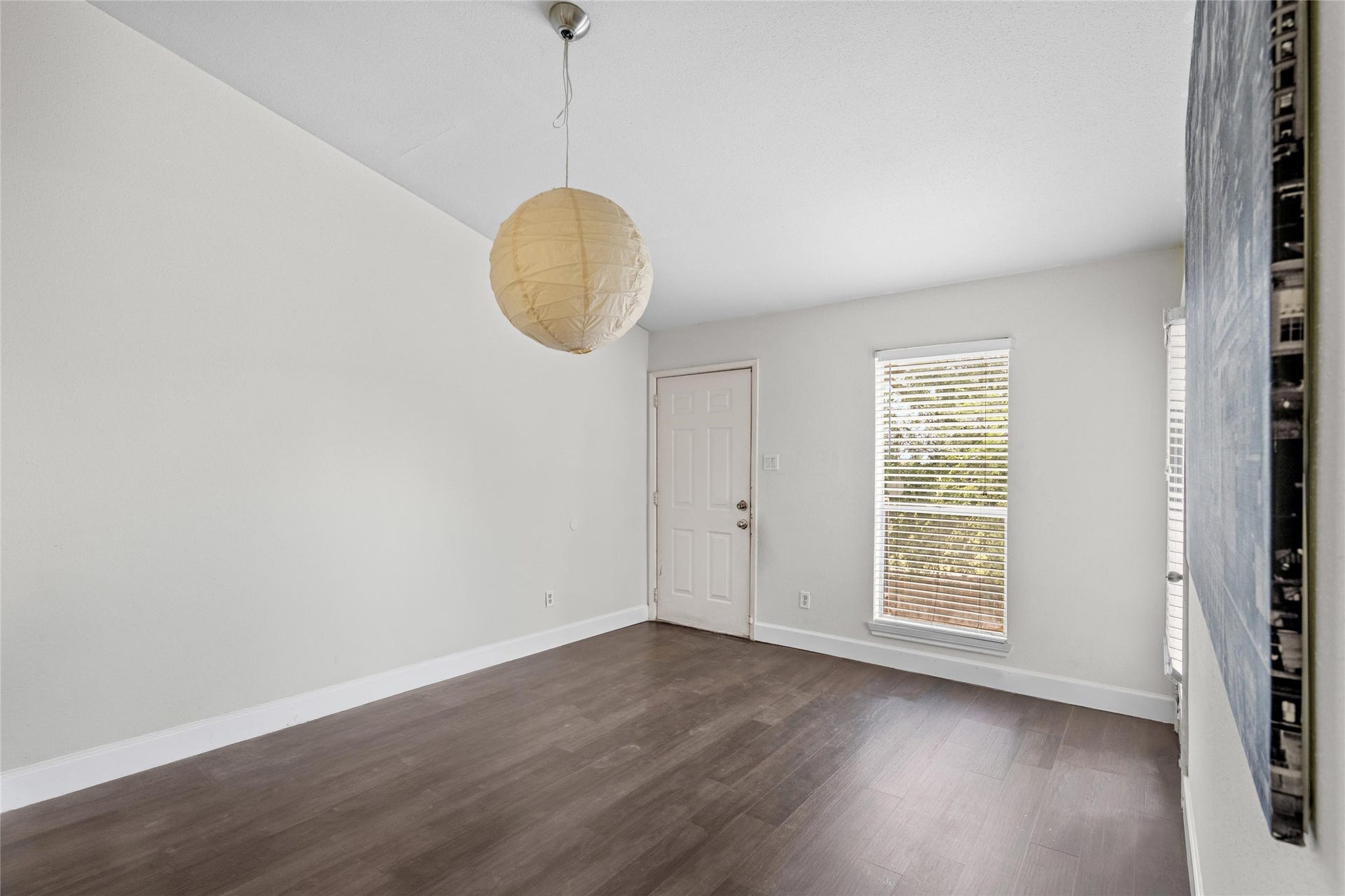 3900 Woodchase Drive, #162, Houston, TX 77042 Spacious living area features durable flooring, neutral walls, and an open feel with natural light from the nearby window.